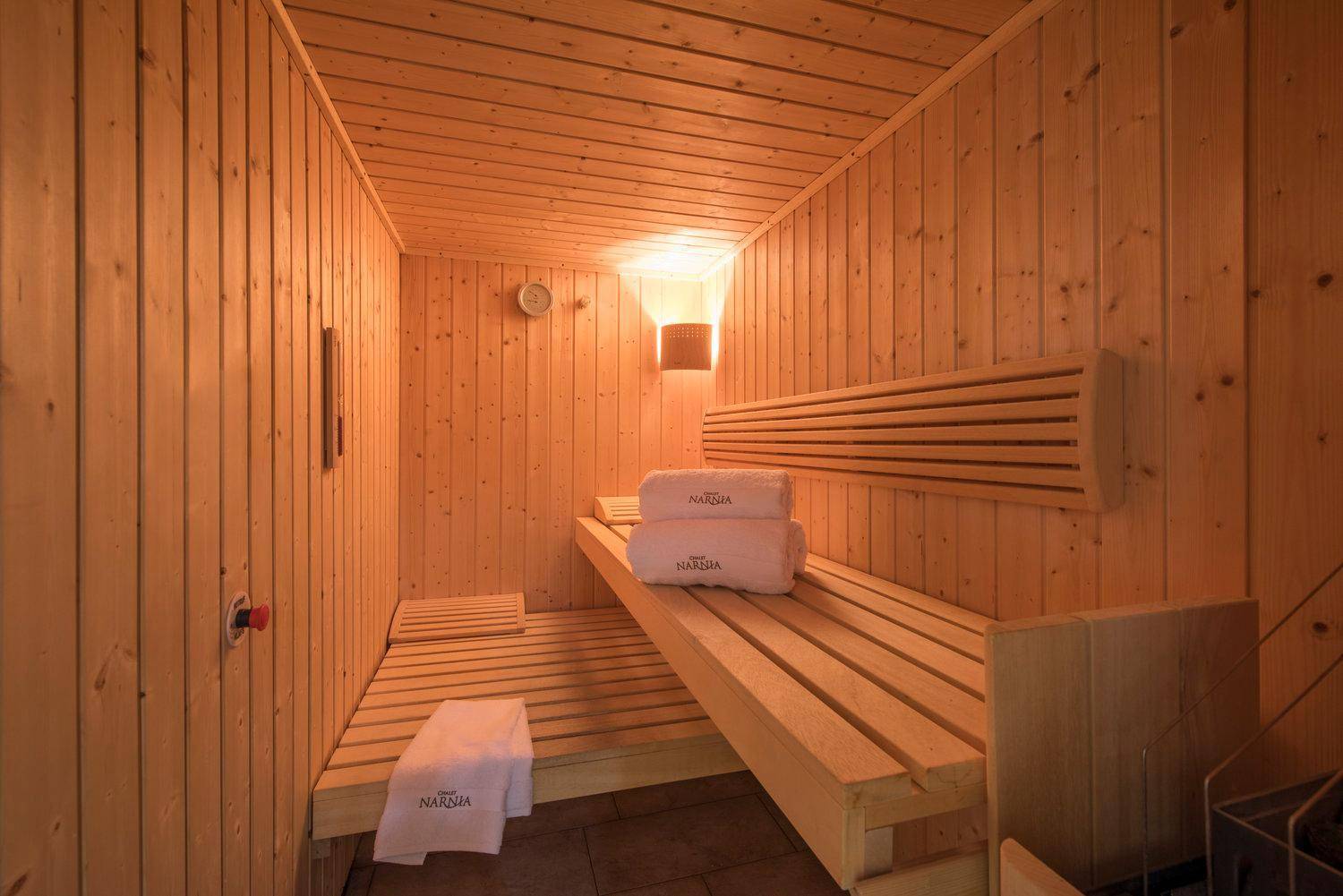 Gemütliche Holzsauna mit Bänken und Handtüchern, bereit zur Entspannung.