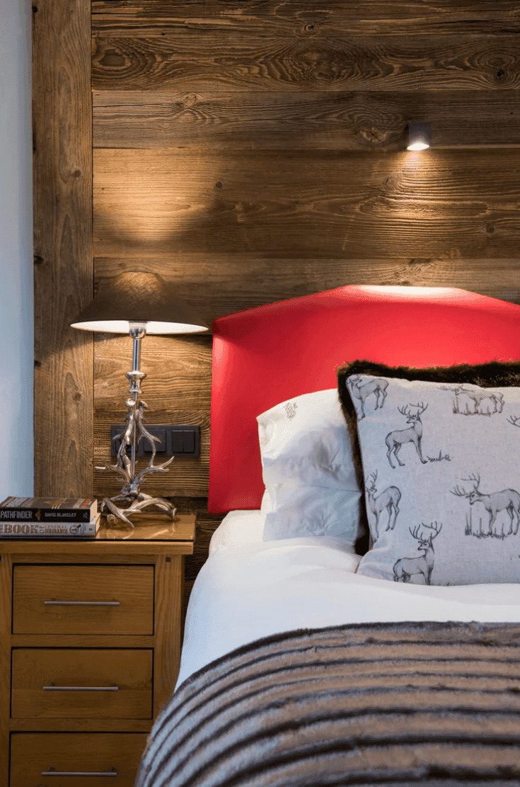 Detailansicht des Nachttisches mit Lampe und Holzkopfteil im Schlafzimmer.