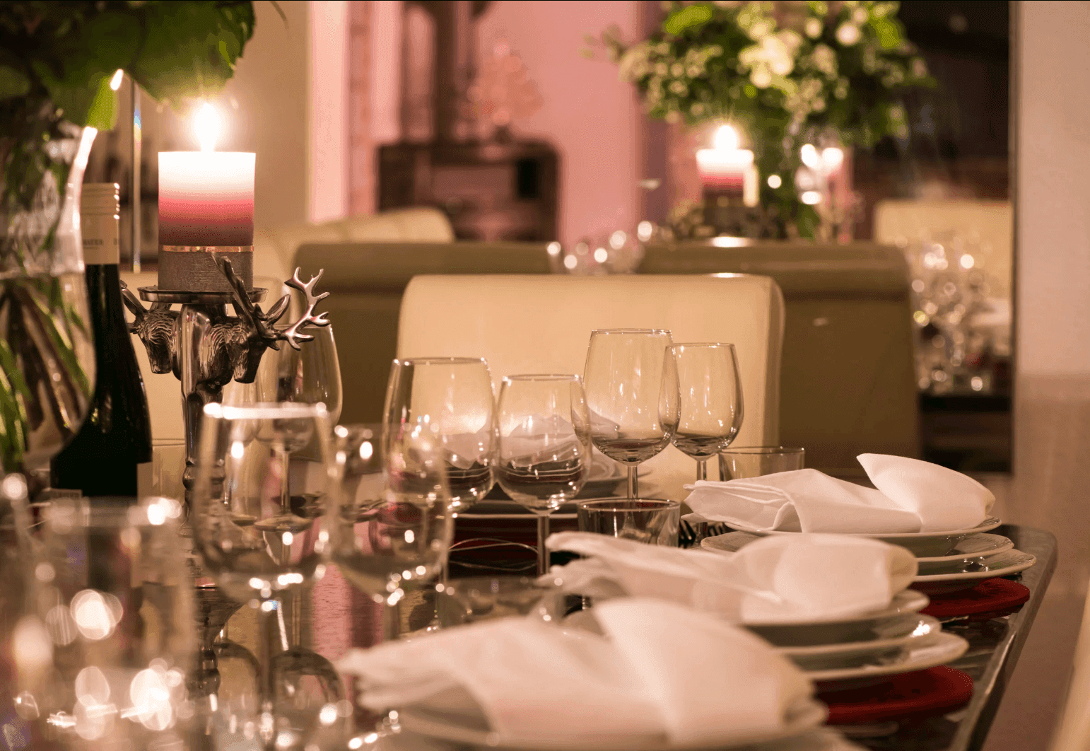 Elegant gedeckter Esstisch mit Kerzen und Weingläsern, bereit für ein festliches Mahl.