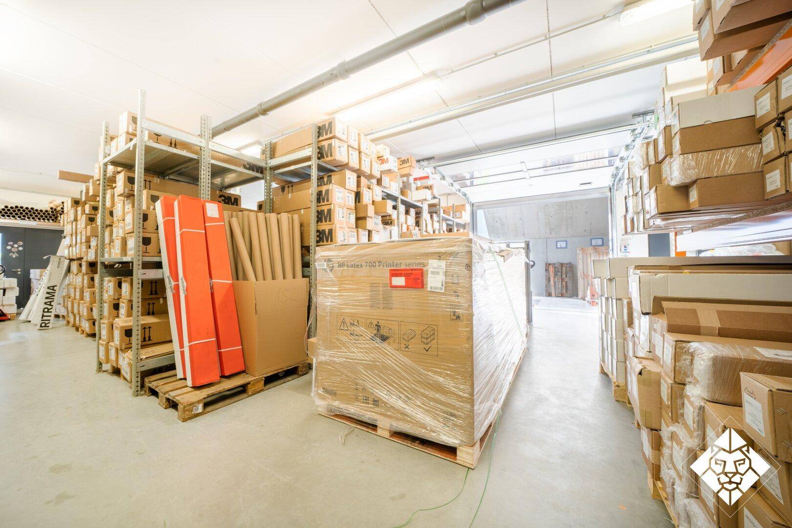 Geräumiger Lagerraum mit hohen Regalen, gefüllt mit verpackten Waren und Kartons.