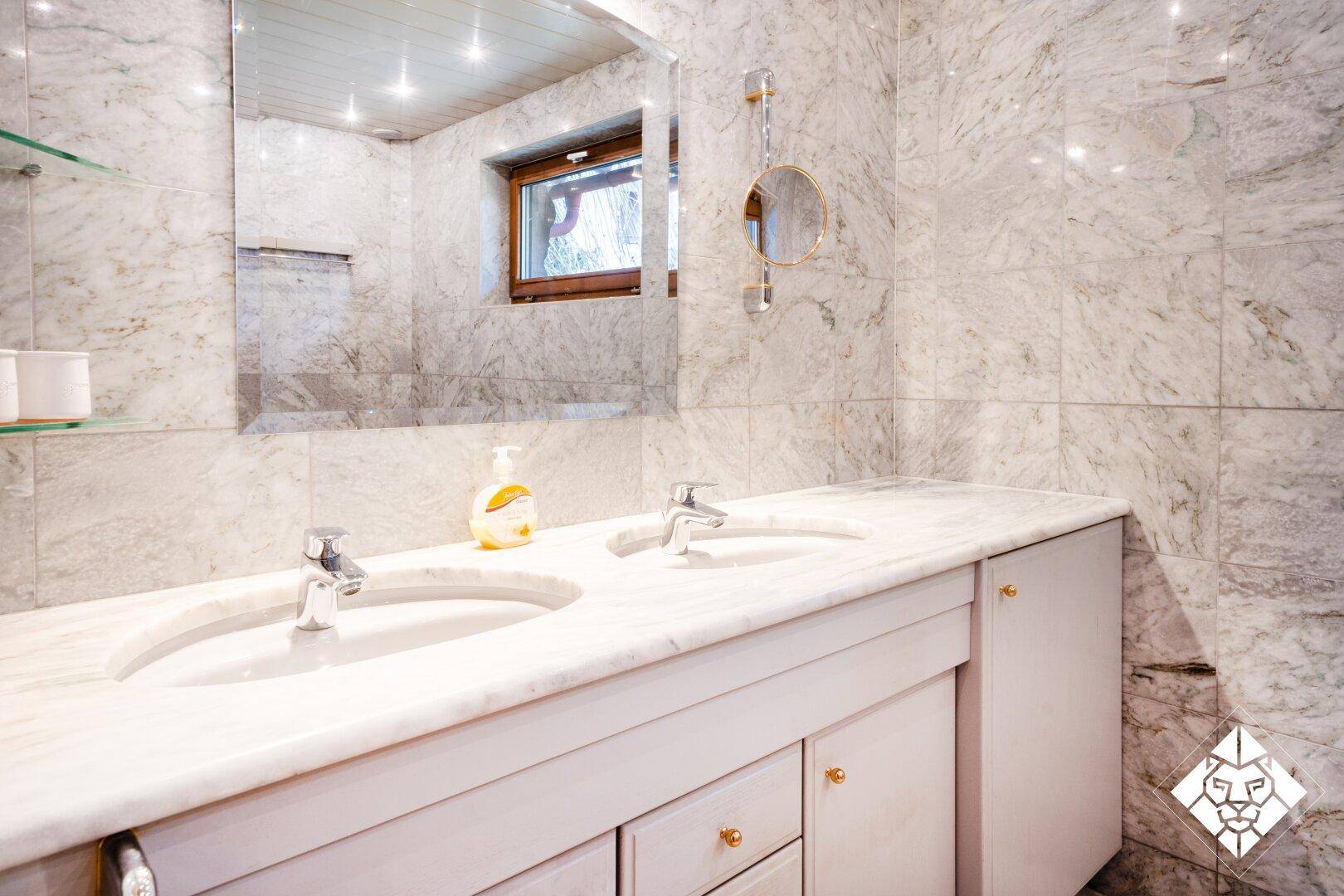 Elegantes Badezimmer mit Doppelwaschbecken und großem Spiegel.