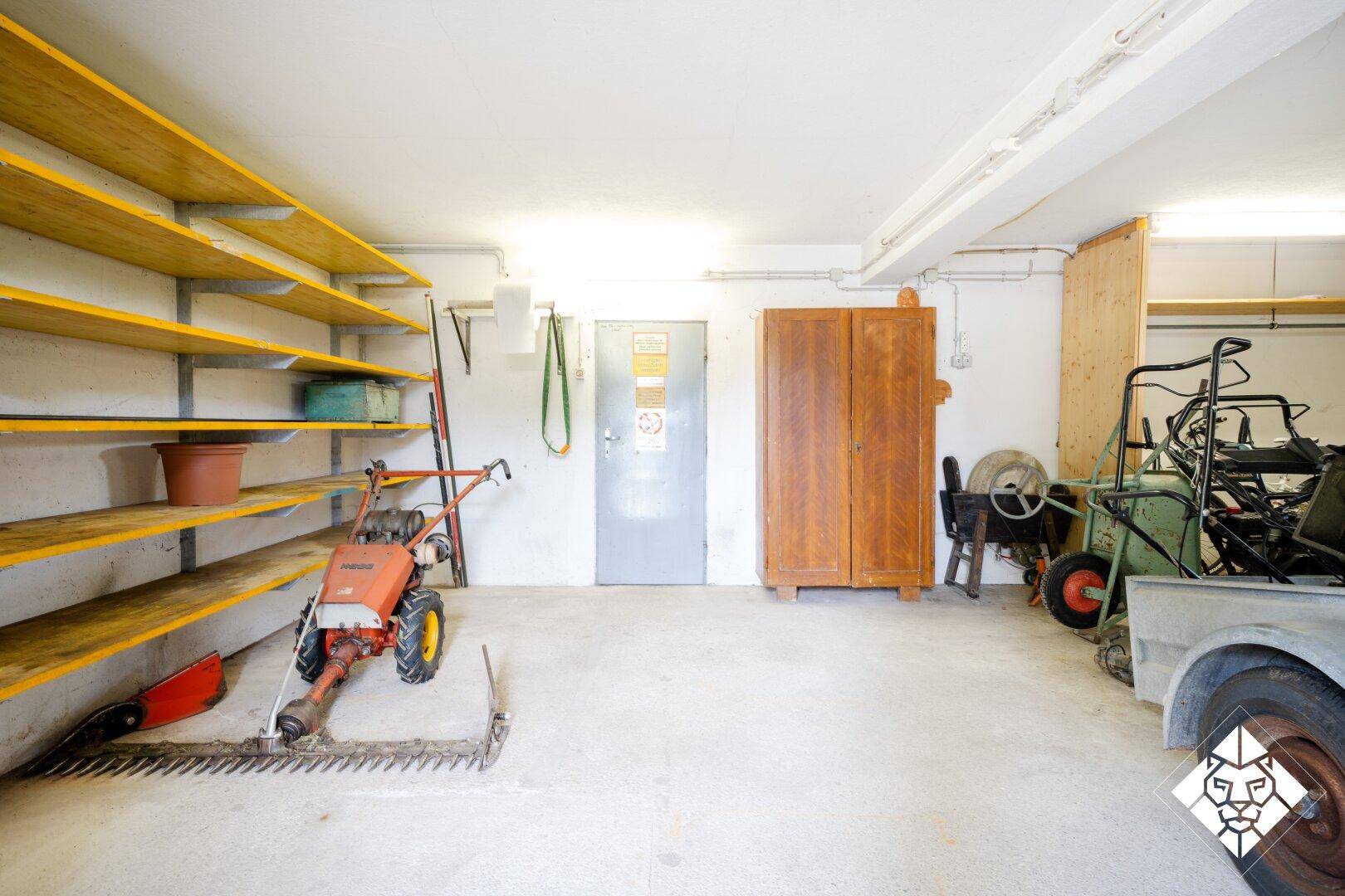 Geräumige Garage oder Werkstatt mit Regalen und verschiedenen Geräten.