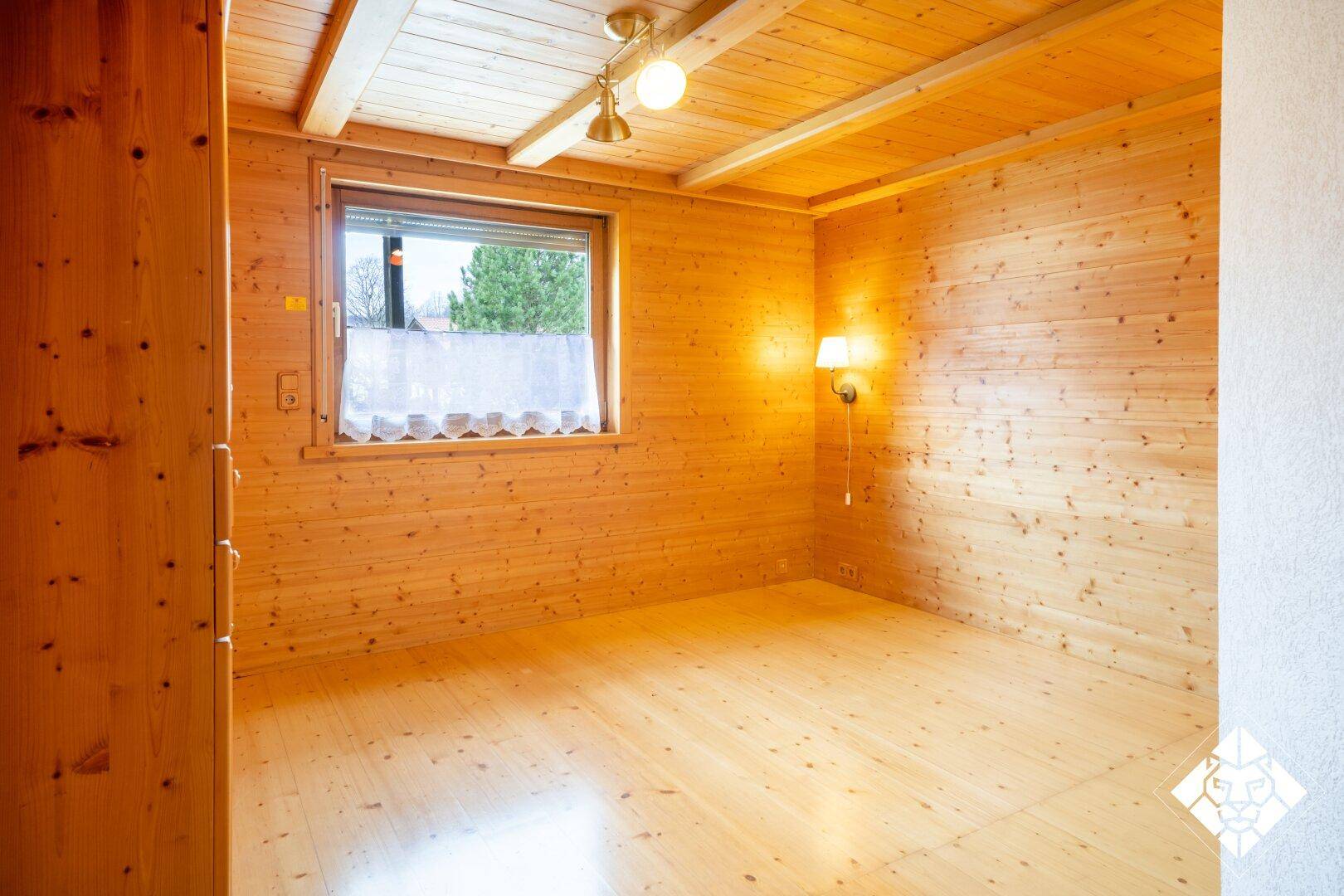 Schlafzimmer mit Holzboden und Holzvertäfelung, bietet eine warme Atmosphäre.