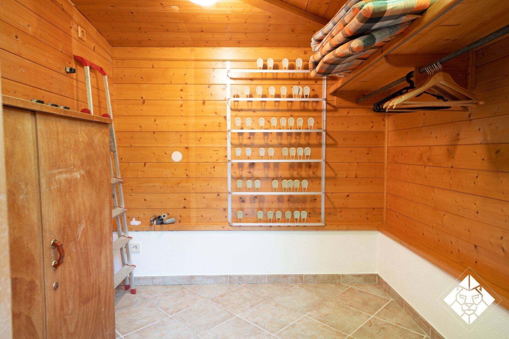 Praktischer Abstellraum mit Holzvertäfelung und Regalsystem für Lagerung.