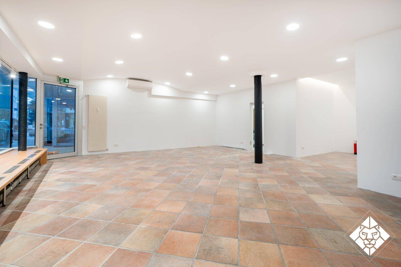 Geräumiger Geschäftsraum mit Terrakotta-Fliesenboden, Klimaanlage und Zugang zur Straße.