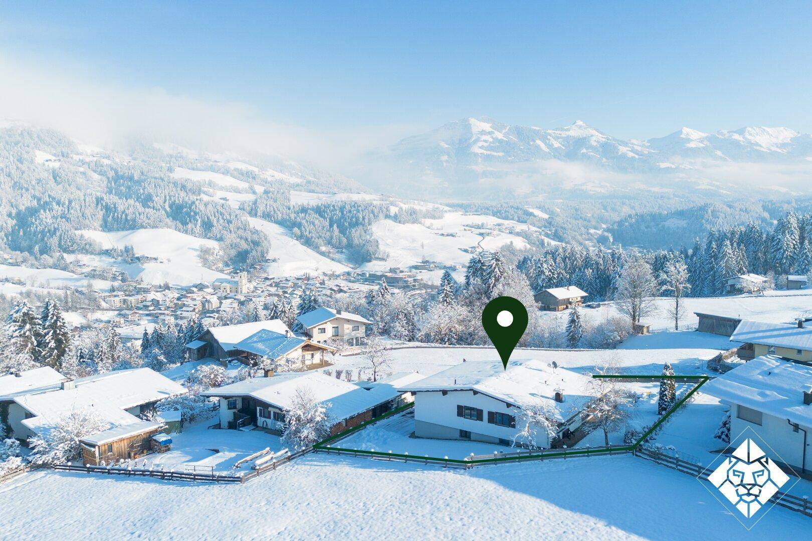Verschneites Haus in ländlicher Umgebung mit markiertem Grundstück und weitem Blick auf die Berge.