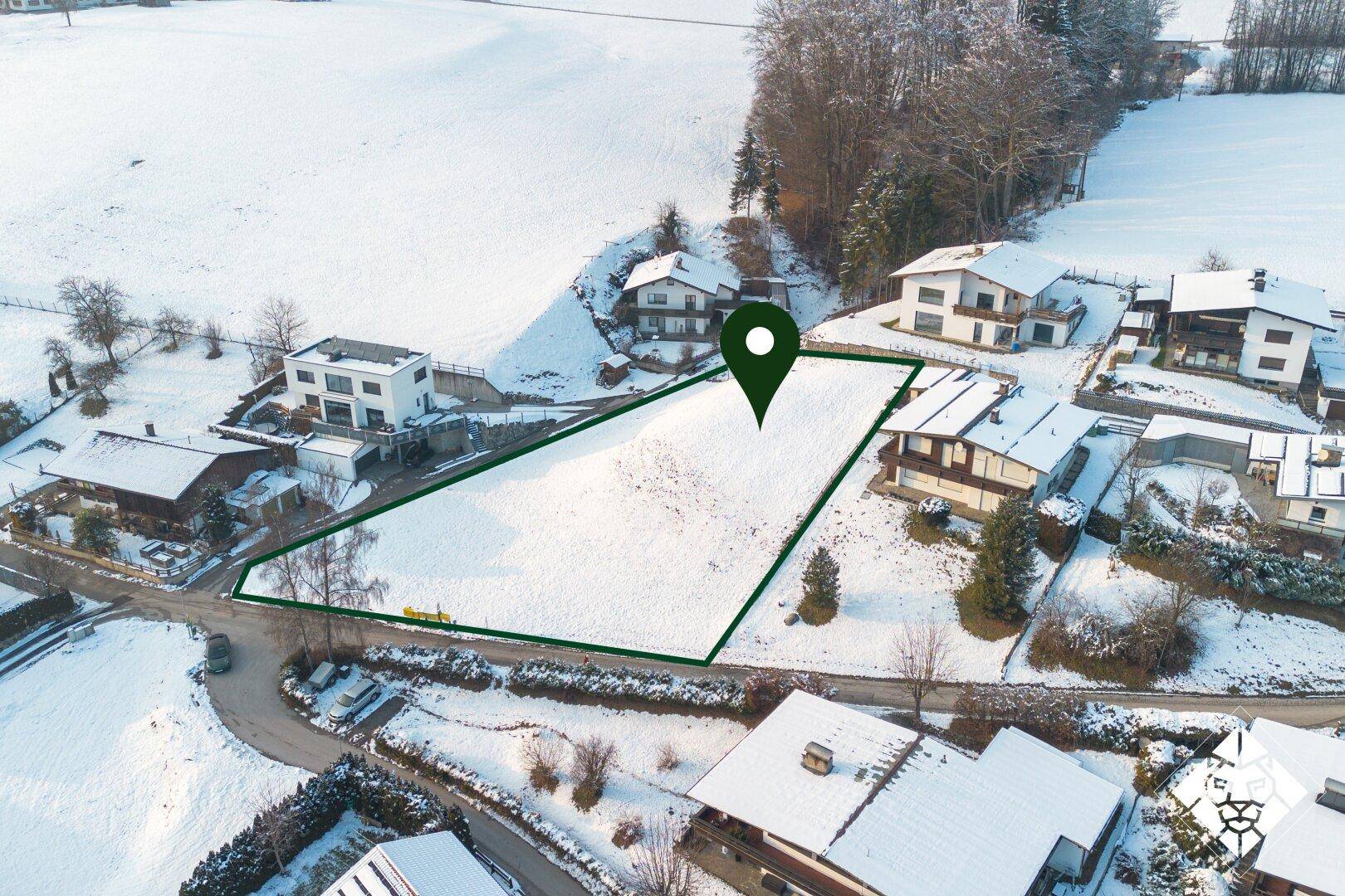 Luftaufnahme eines schneebedeckten Grundstücks, umgeben von Wohnhäusern, mit einem Standort-Pin.