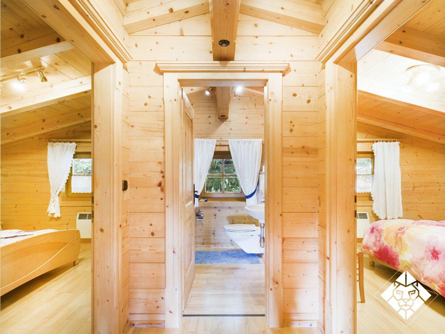 Heller Flur mit Holzvertäfelung und Dachschrägen, der zu Schlafzimmern und einem Badezimmer führt.