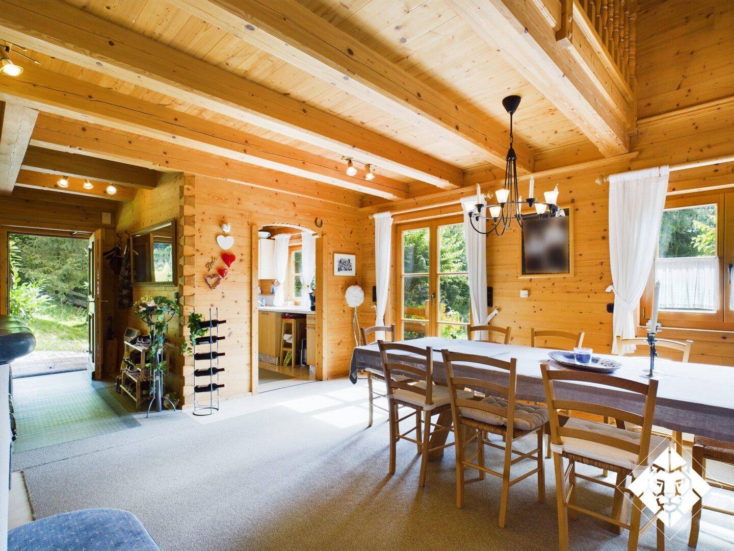 Geräumiger Essbereich mit Holztisch und Stühlen, offen zum Wohnbereich, mit Zugang zum Garten.