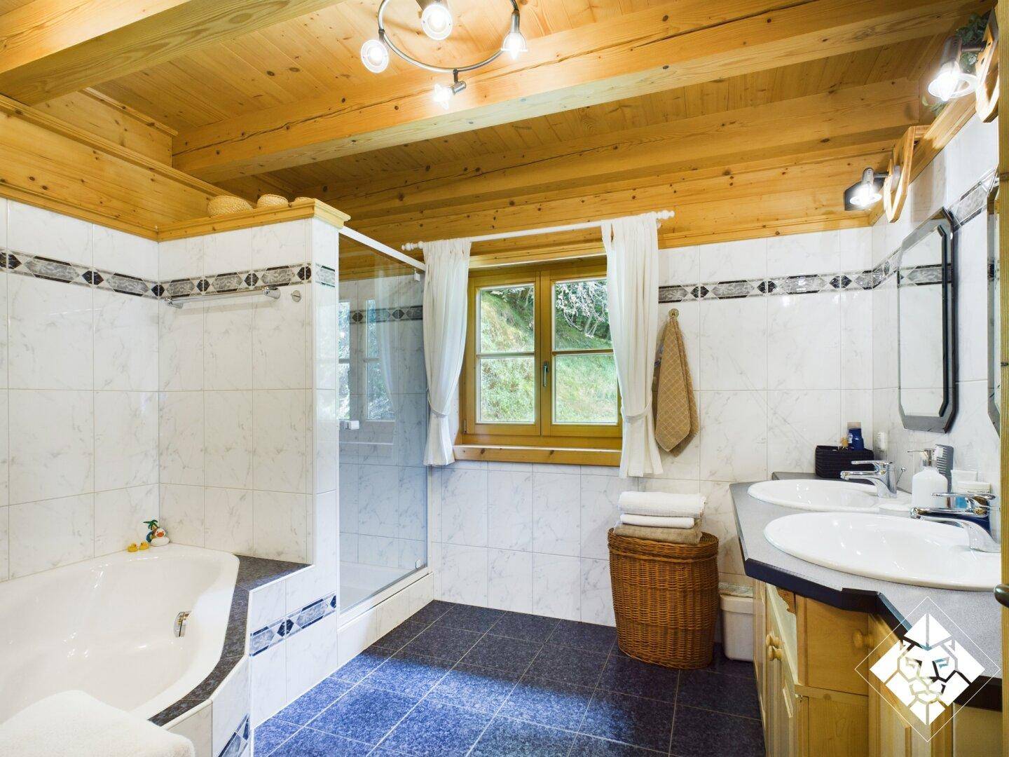 Geräumiges Badezimmer mit Badewanne, Dusche, Doppelwaschbecken und Fenster.