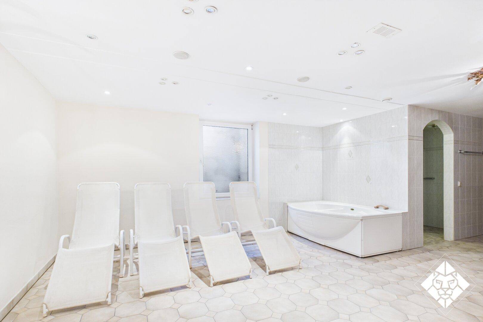 Wellnessbereich mit Liegestühlen und einem Whirlpool, ideal zur Entspannung und Erholung.