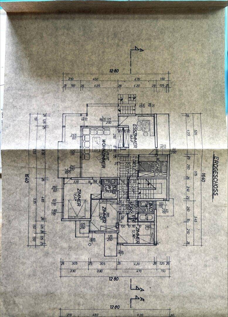 Grundriss des Erdgeschosses mit Wohnzimmer, Esszimmer und zwei weiteren Zimmern.