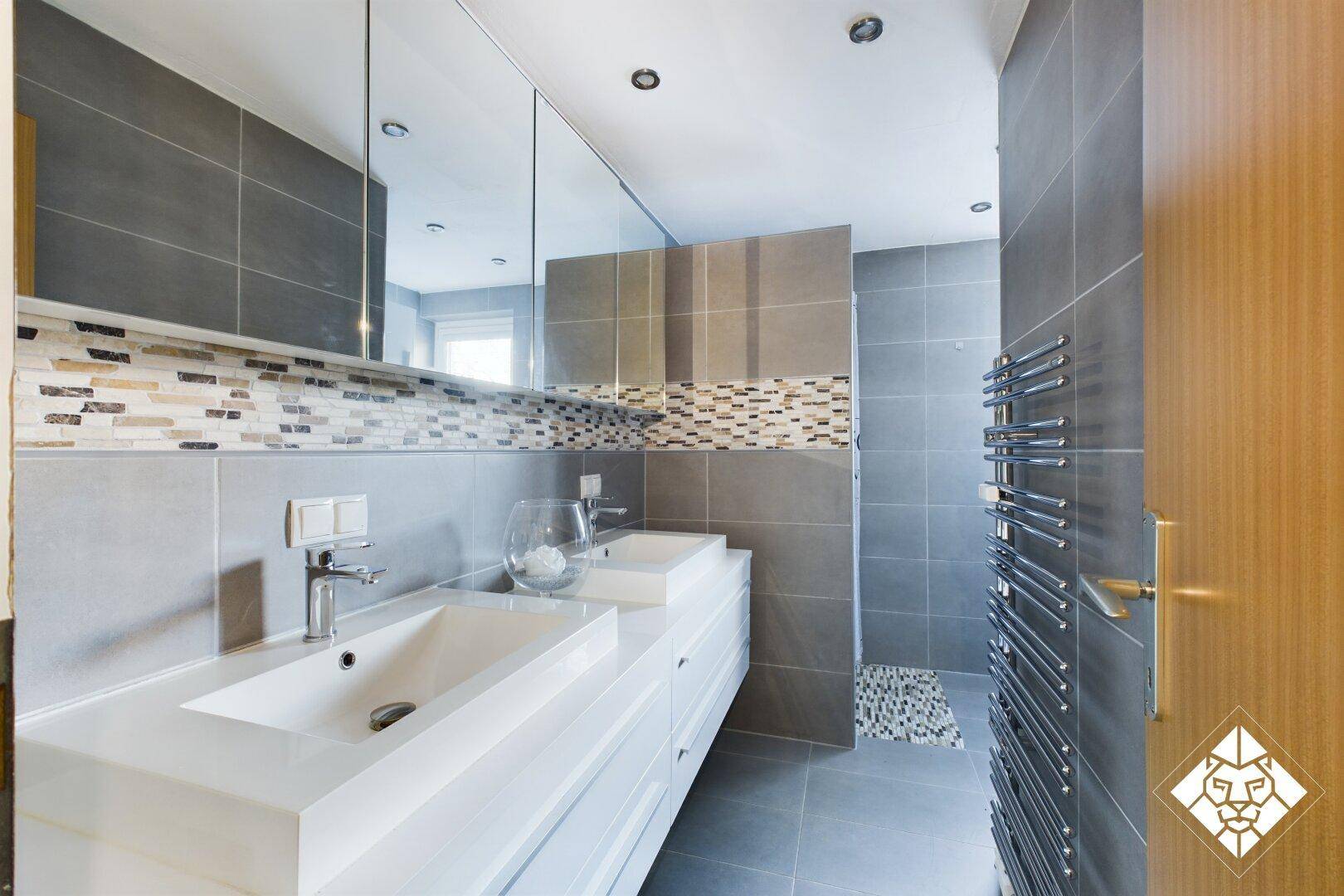 Modernes Badezimmer mit Doppelwaschbecken, großem Spiegelschrank und begehbarer Dusche.