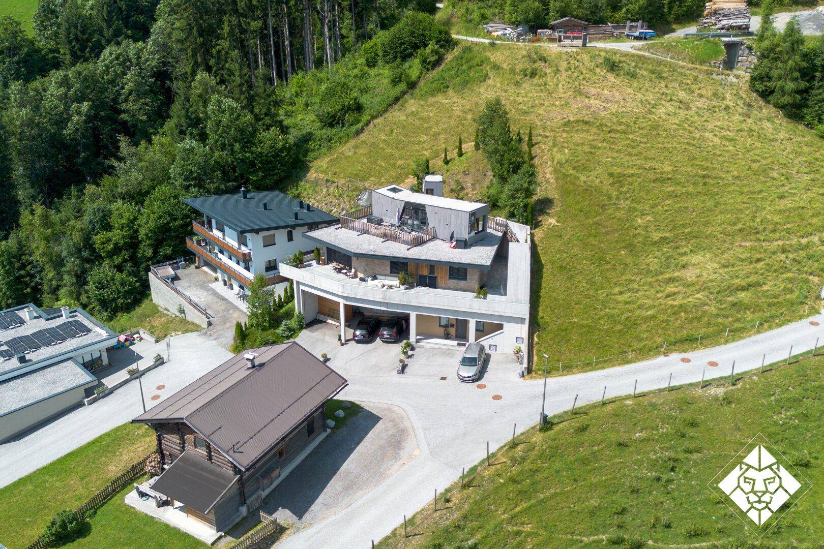 Moderne Architektur in alpiner Landschaft mit mehreren Gebäuden und viel Grün.