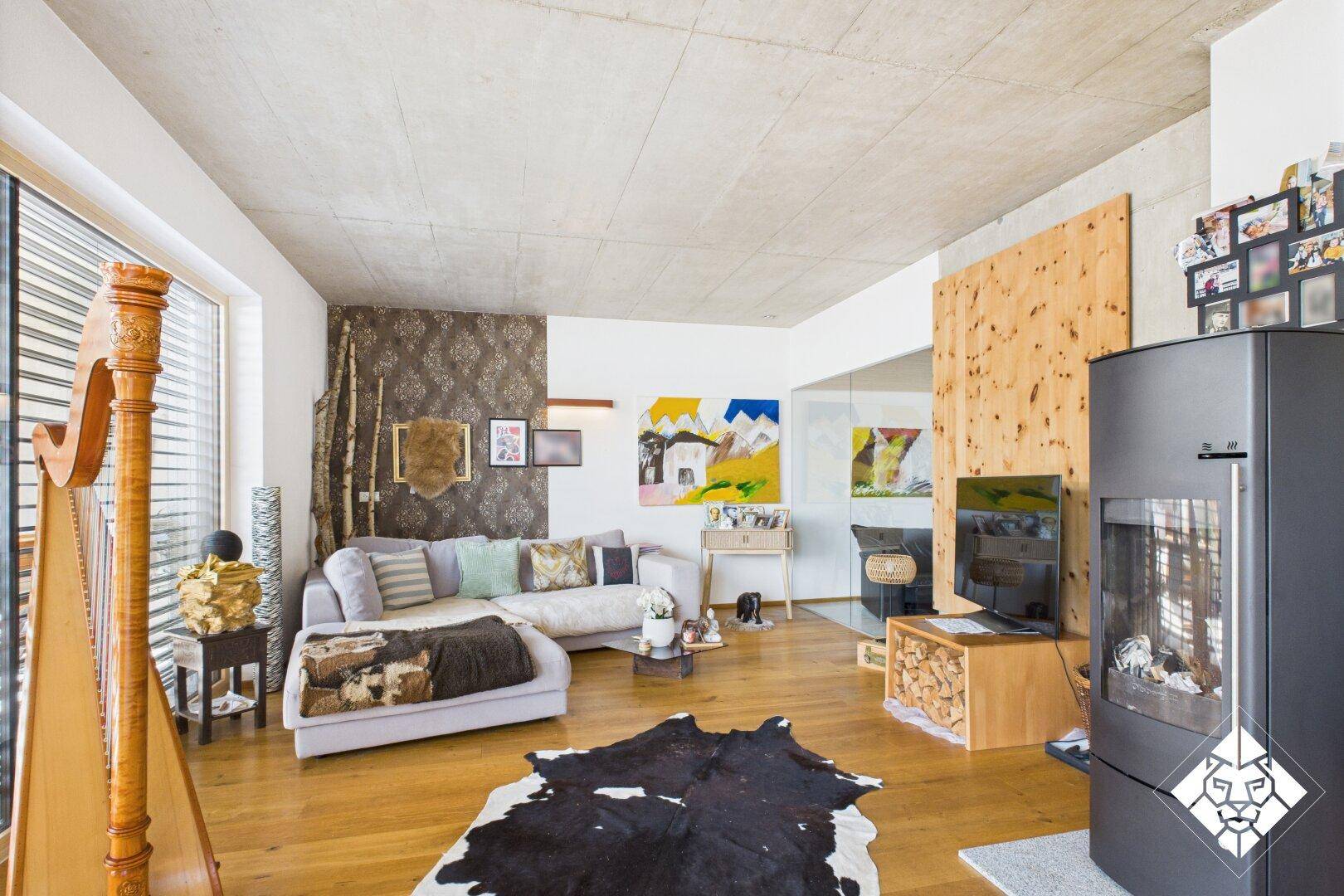 Gemütliches Wohnzimmer mit Holzboden, modernem Kamin und rustikalen Dekorationselementen.
