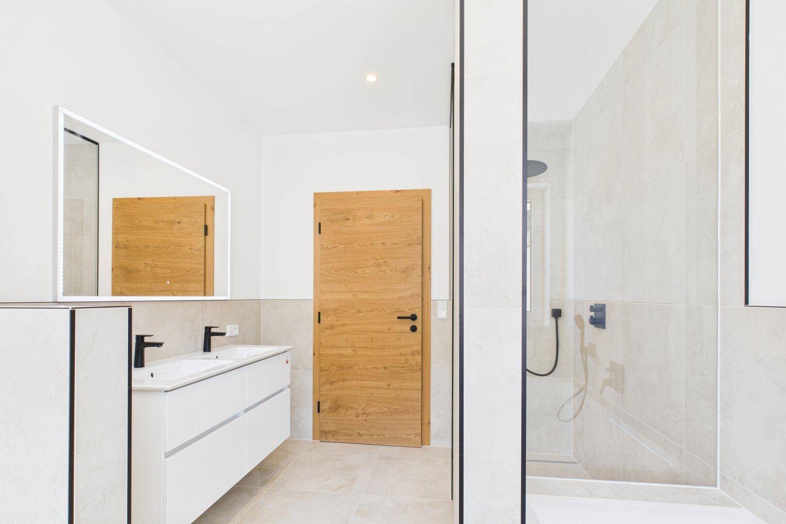 Modernes Badezimmer mit Doppelwaschbecken, großem Spiegel und ebenerdiger Dusche.
