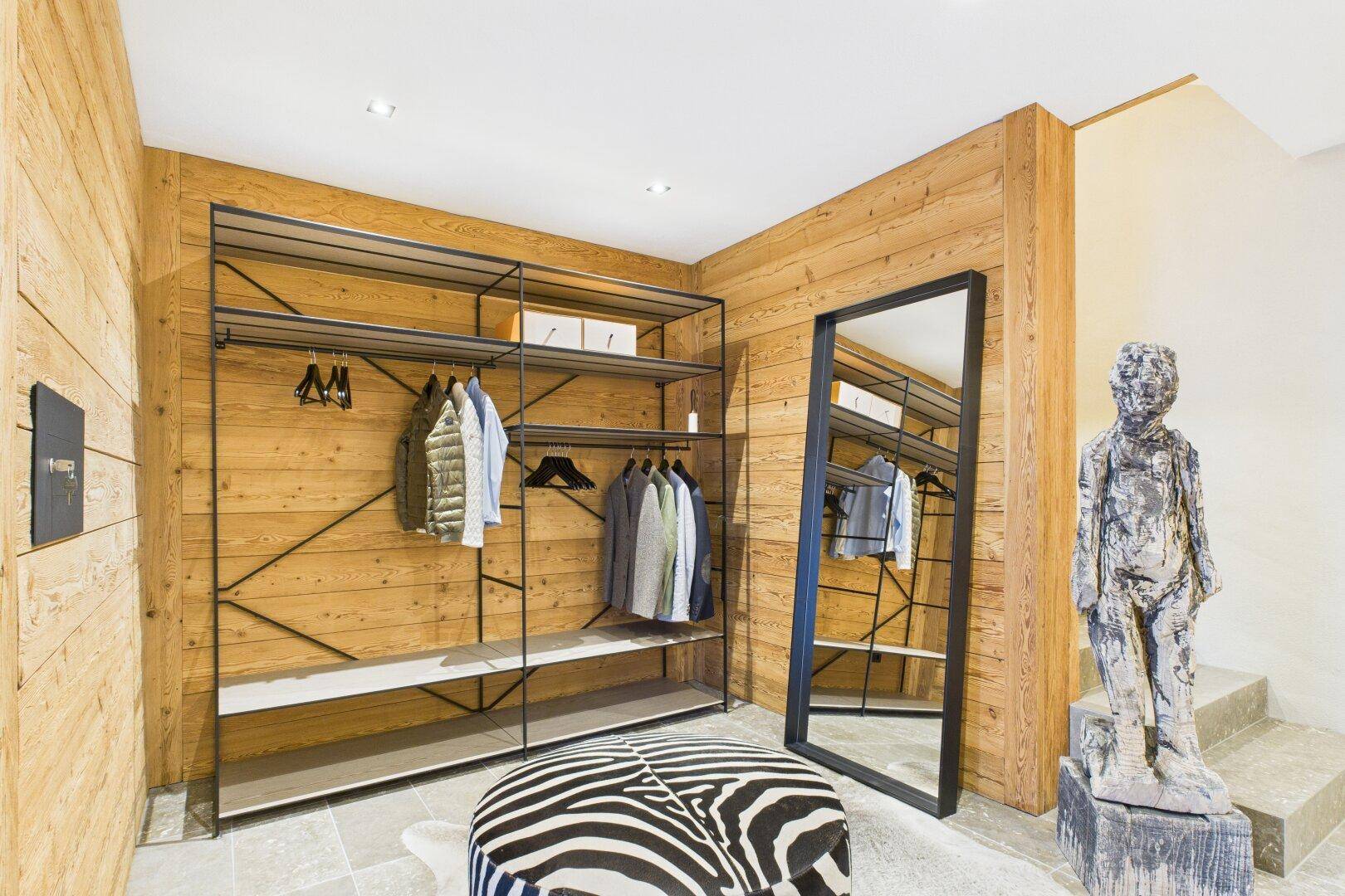 Geräumiger begehbarer Kleiderschrank mit offenen Regalsystemen und Ganzkörperspiegel.