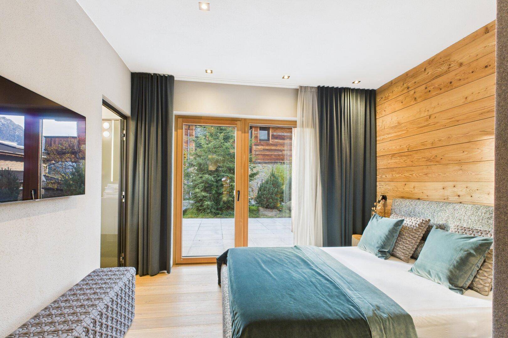Helles Schlafzimmer mit Einbauschränken und direktem Zugang zum Gartenbereich.