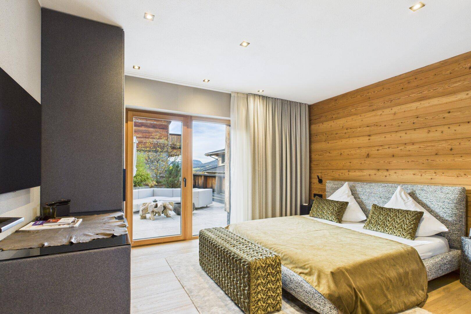 Elegantes Schlafzimmer mit Doppelbett und direktem Zugang zur privaten Terrasse.