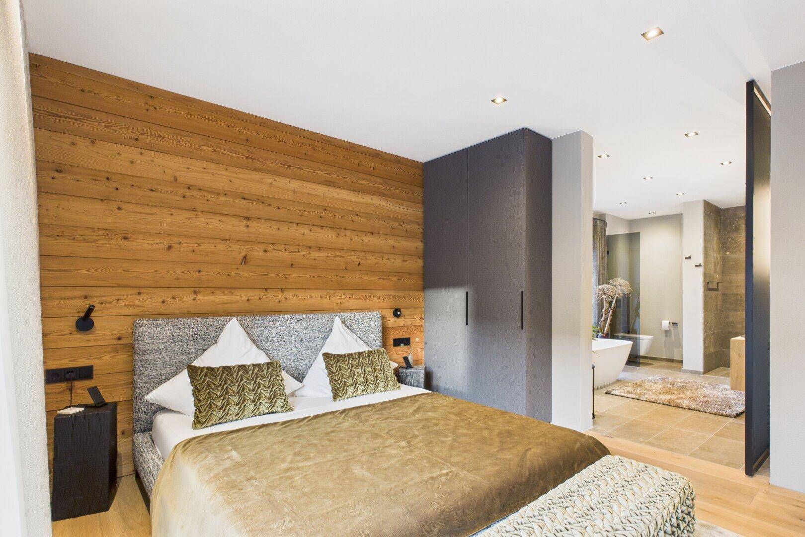 Geräumiges Schlafzimmer mit offener Verbindung zu einem luxuriösen Badezimmer.