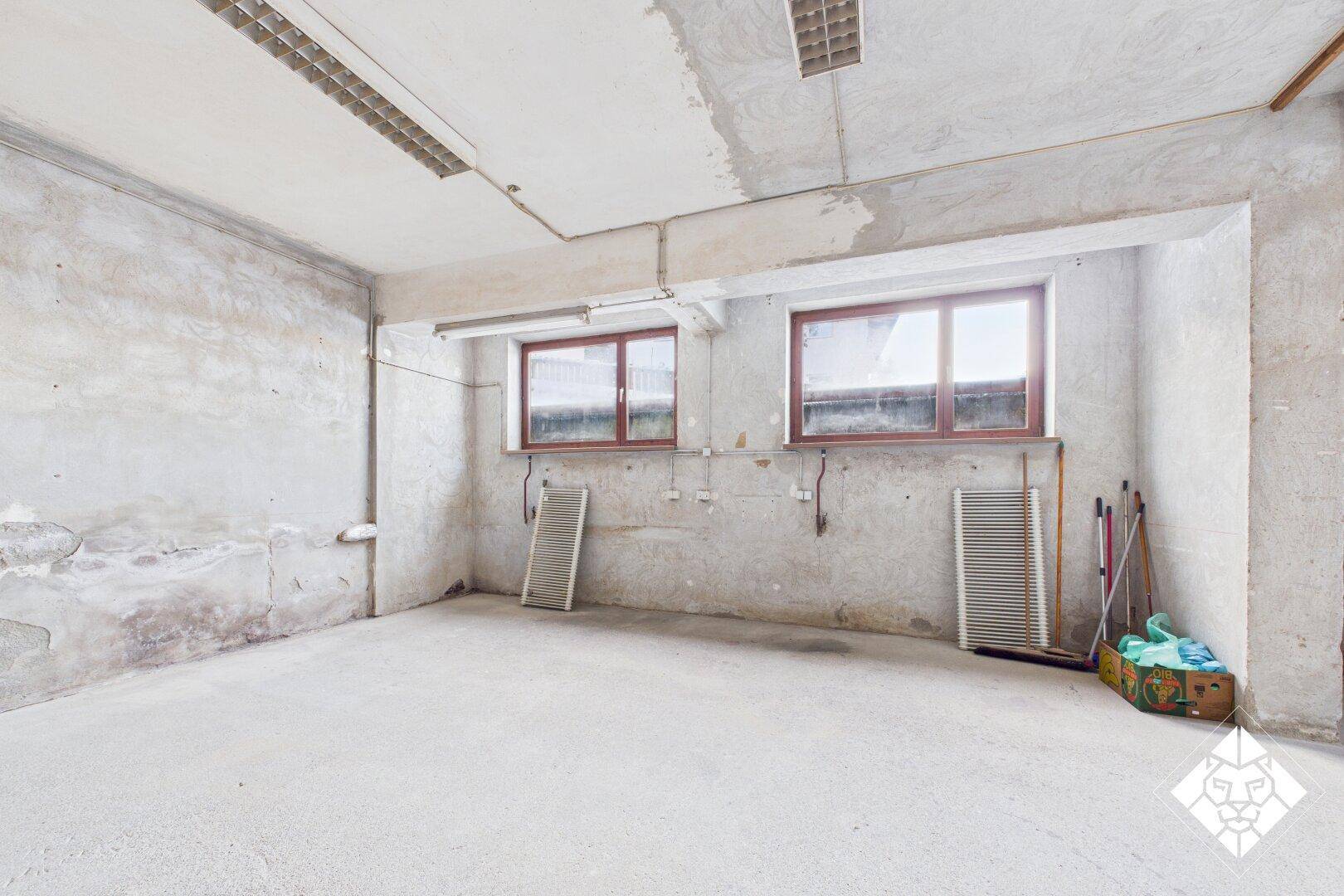 Unfertiger Kellerraum mit Betonboden und Fenstern, ideal für Lagerung oder Ausbau.