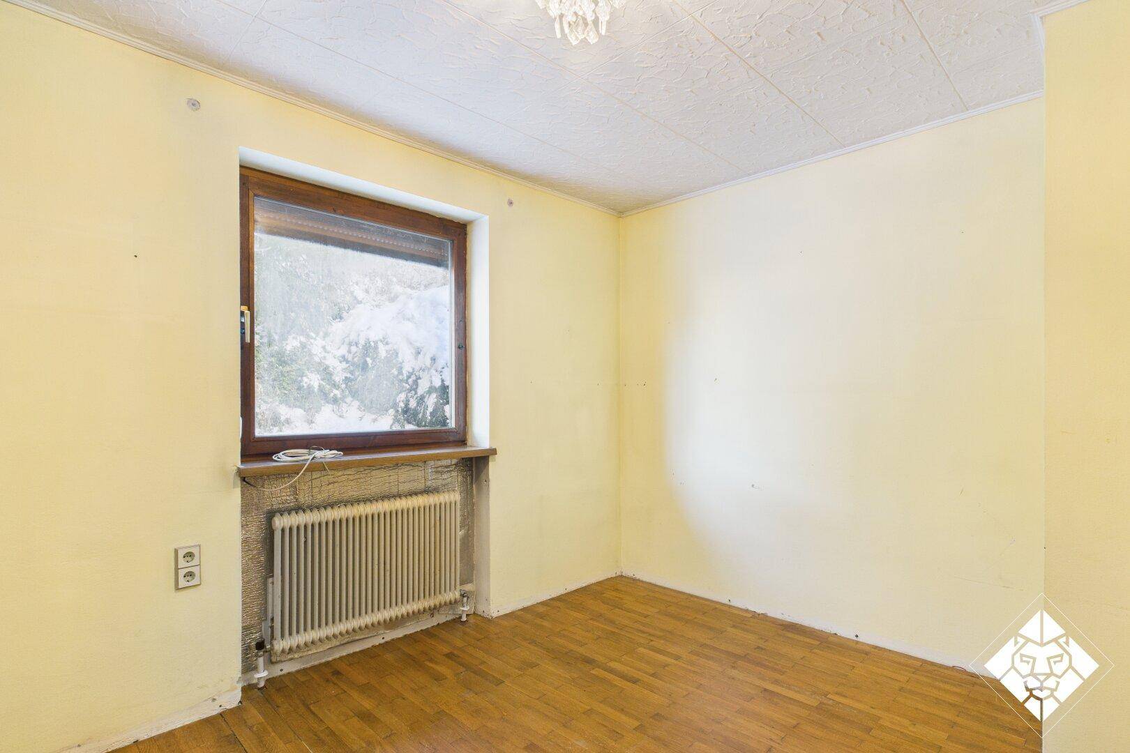 Helles Schlafzimmer mit Parkettboden und gelben Wänden, ideal für eine gemütliche Einrichtung.