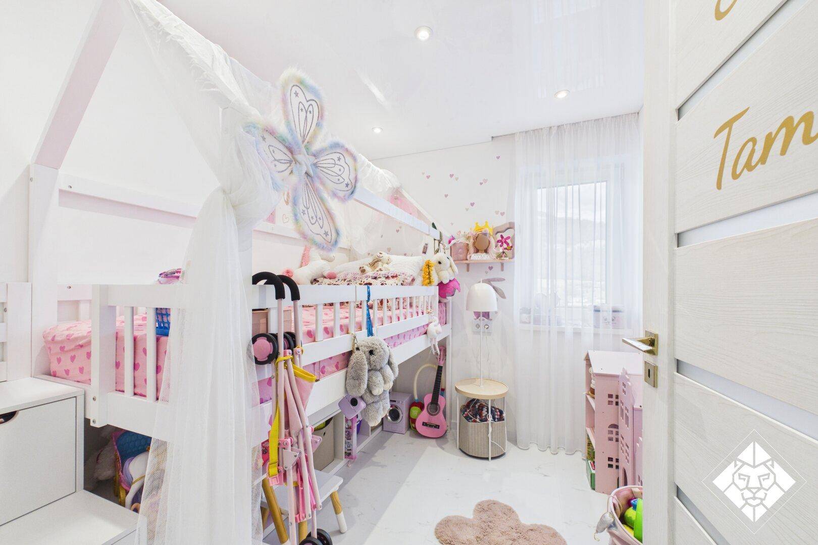 Farbenfrohes Kinderzimmer mit Hochbett, Spielzeug und hellem Ambiente.