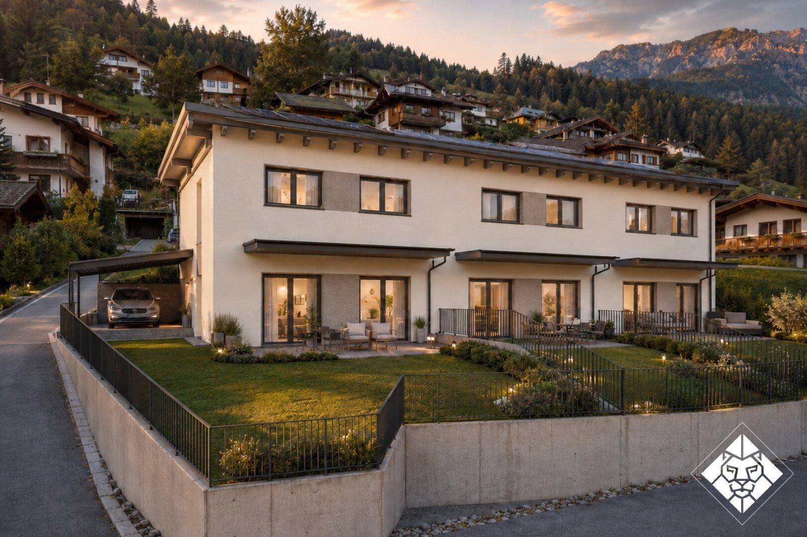 Moderne Reihenhäuser in alpiner Landschaft mit Gärten, Terrassen und Bergblick.