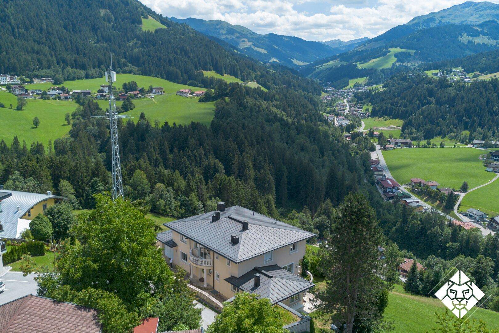 Luftaufnahme des Anwesens eingebettet in die grüne Berglandschaft mit weitem Blick.