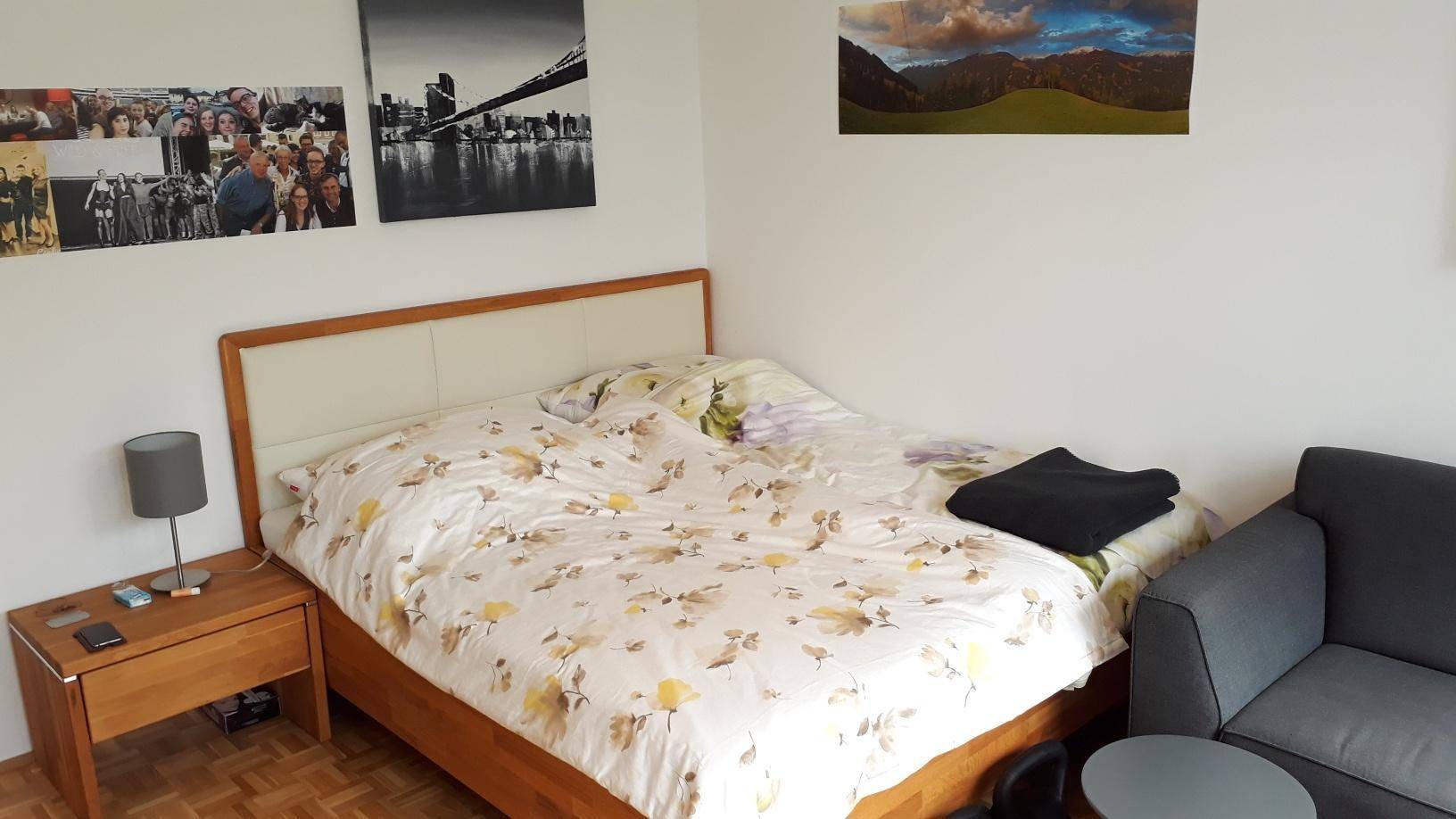 Gemütliches Schlafzimmer mit Doppelbett, Nachttisch und Parkettboden.