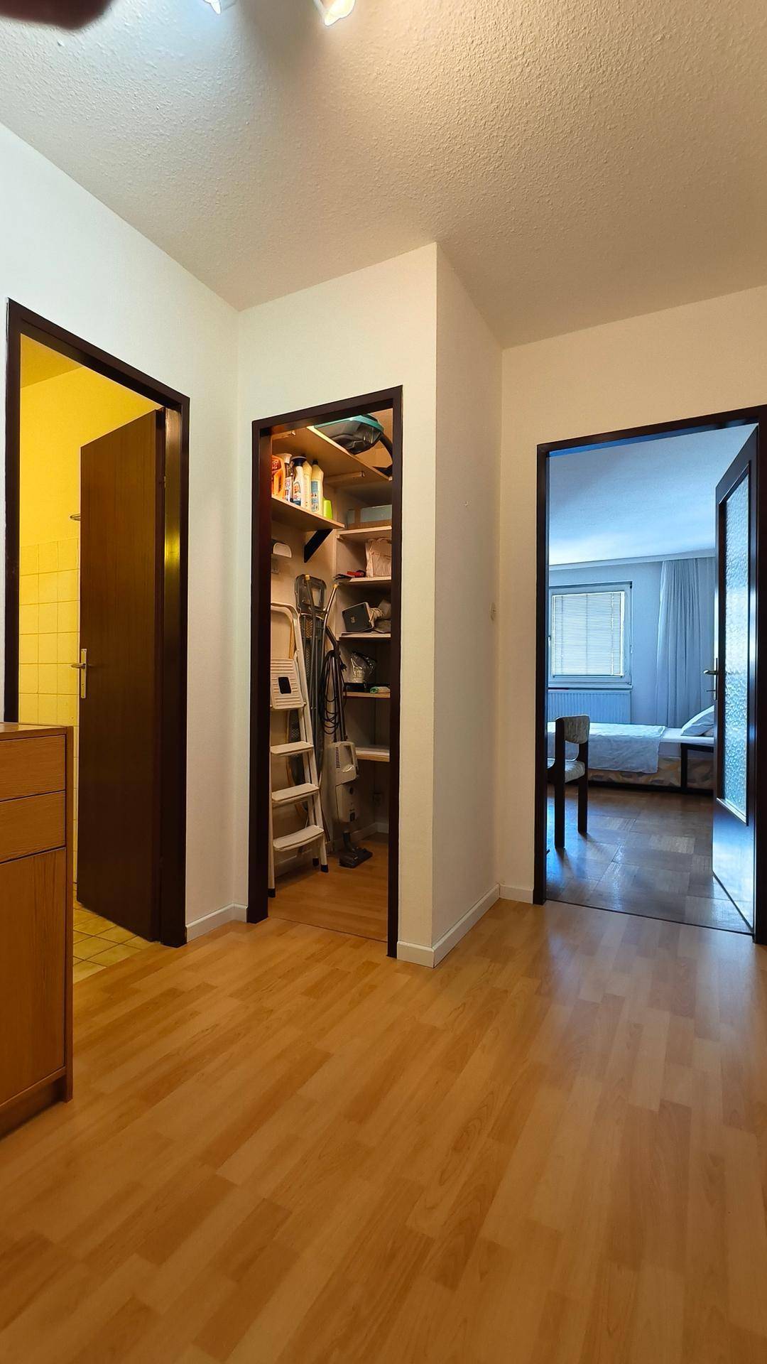 Heller Flur mit Parkettboden und Zugängen zu Schlafzimmer, Bad und Abstellraum.
