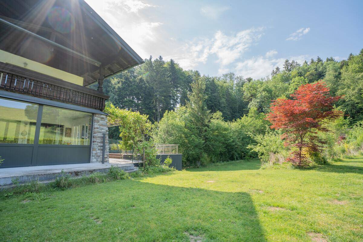 Seitlicher Blick auf das Haus mit großem Garten und viel Grünfläche.