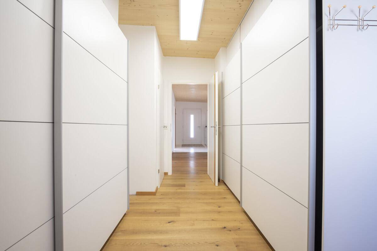 Heller Flur mit Holzboden und Holzdecke, ausgestattet mit praktischen Einbauschränken.