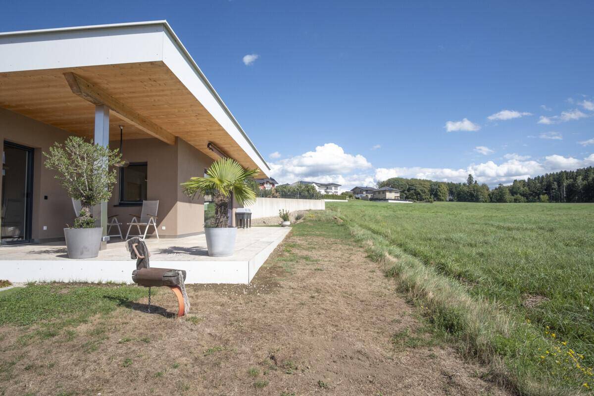 Große Terrasse mit Topfpflanzen und weitem Blick über die grüne Landschaft.
