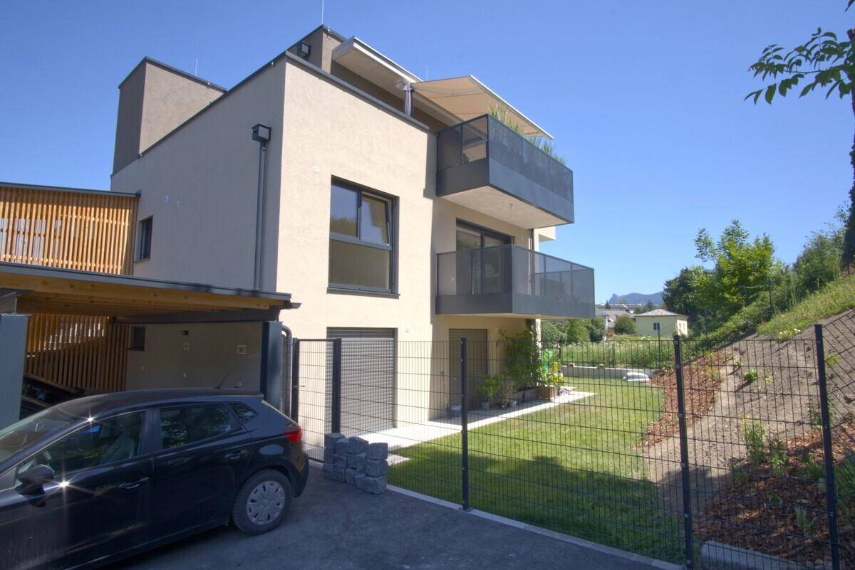 Moderne Wohnanlage mit mehreren Balkonen, Carport und gepflegter Rasenfläche.