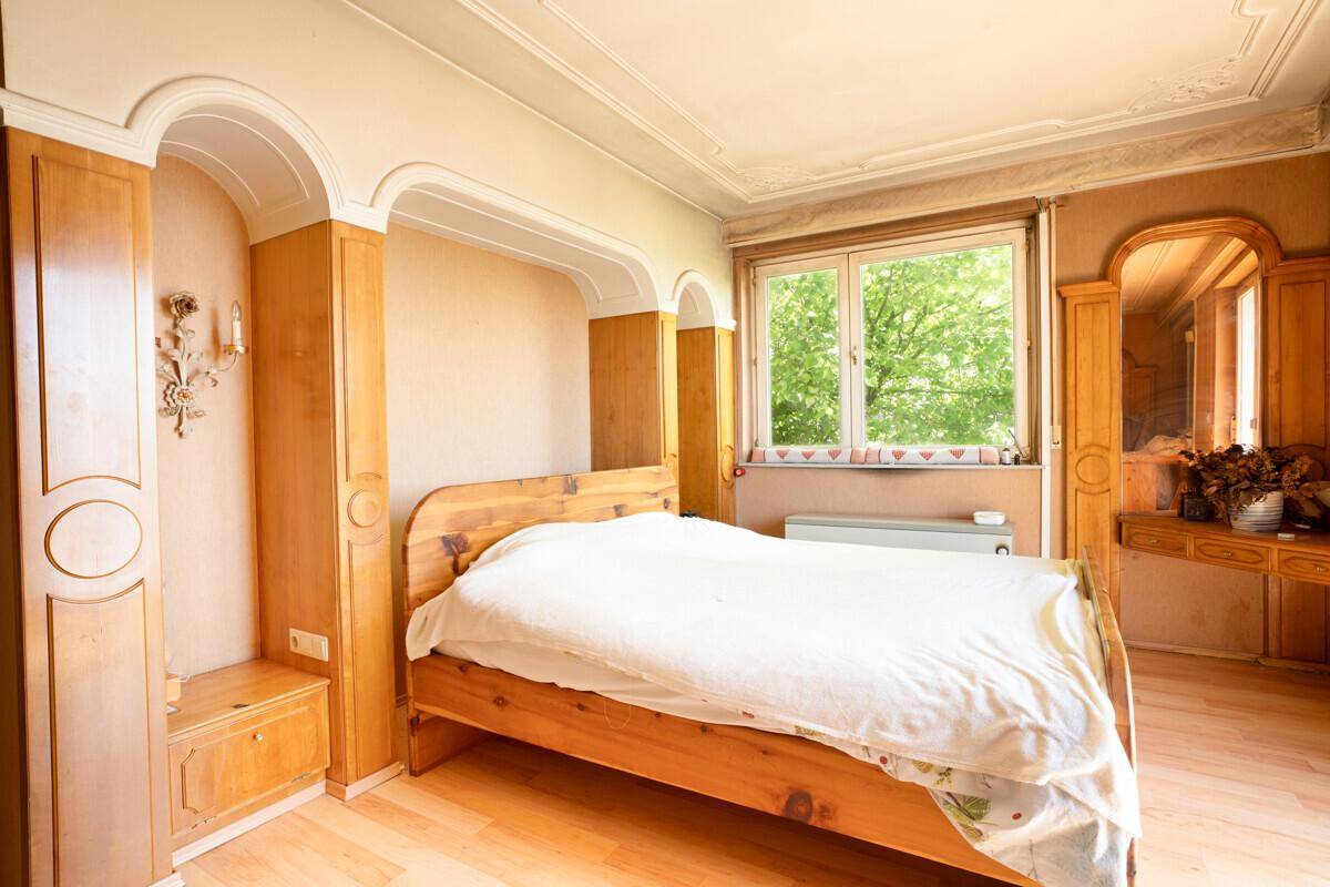 Schlafzimmer mit Holzbett und integrierten Schränken, hell und geräumig.