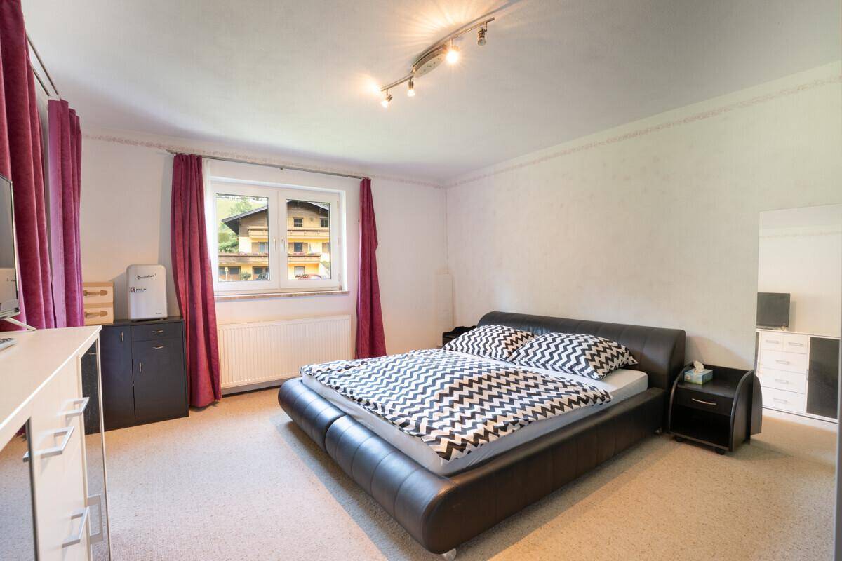 Modern eingerichtetes Schlafzimmer mit Doppelbett und Teppichboden.