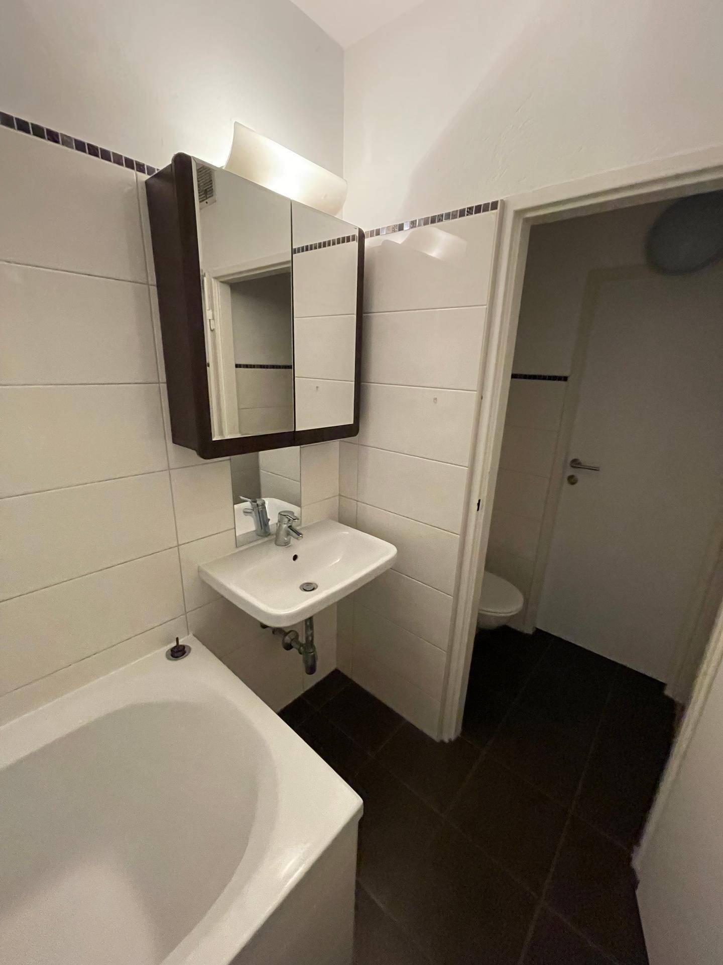 Badezimmer mit Badewanne, Waschbecken und Spiegelschrank, in einem funktionalen Design.