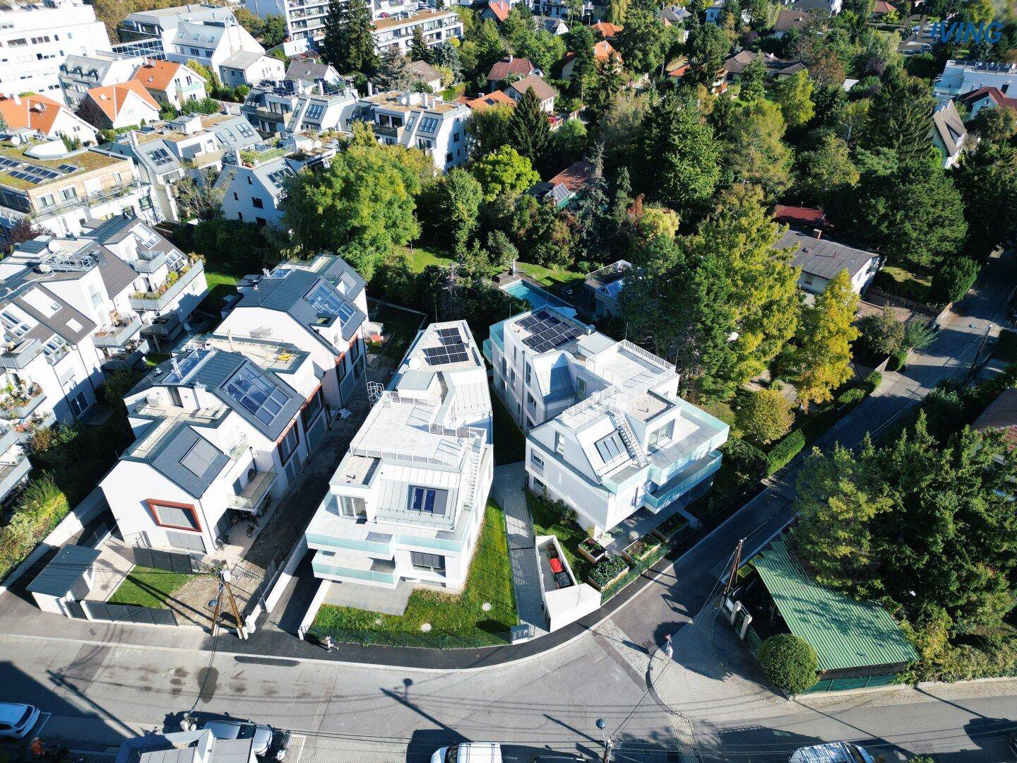 Übersicht moderner Wohngebäude in einer grünen Wohngegend mit viel Baumbestand.