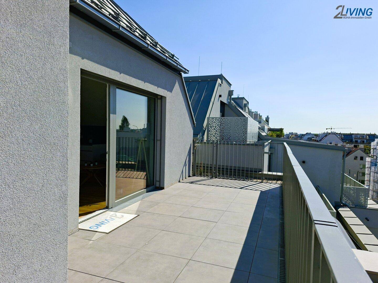 Geräumige Dachterrasse mit Fliesenboden und Metallgeländer, ideal für Entspannung im Freien.