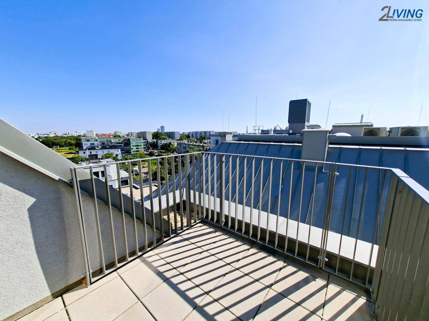 Weitläufige Dachterrasse mit Panoramablick über die Stadt und umliegende Grünflächen.