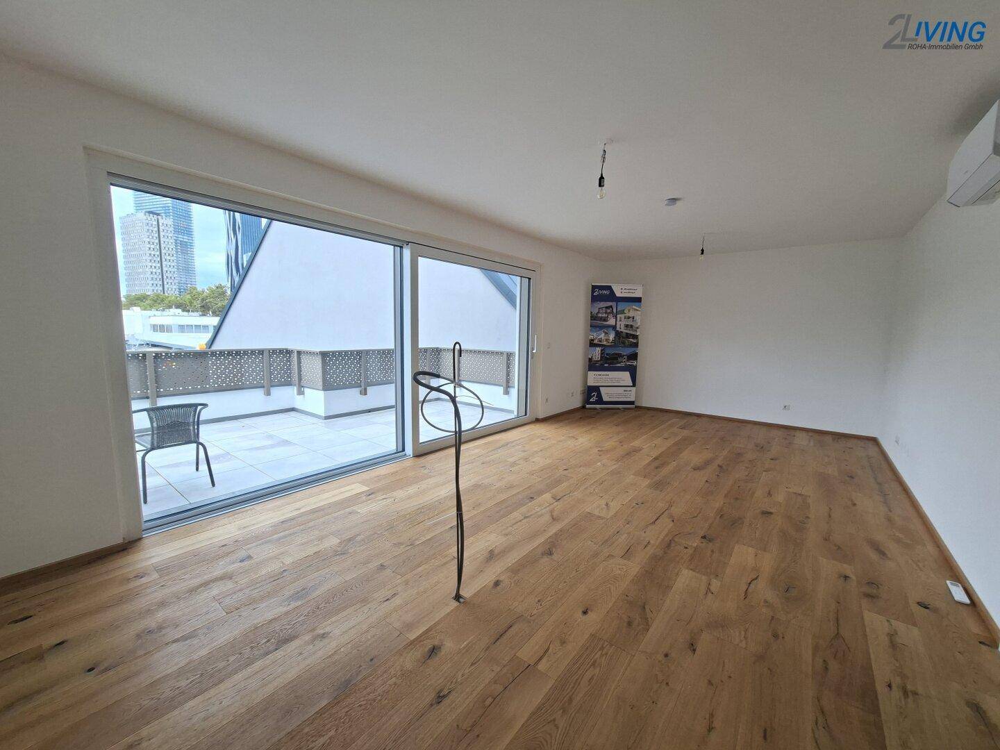 Geräumiges Wohnzimmer mit Parkettboden und großen Schiebetüren zur Terrasse.