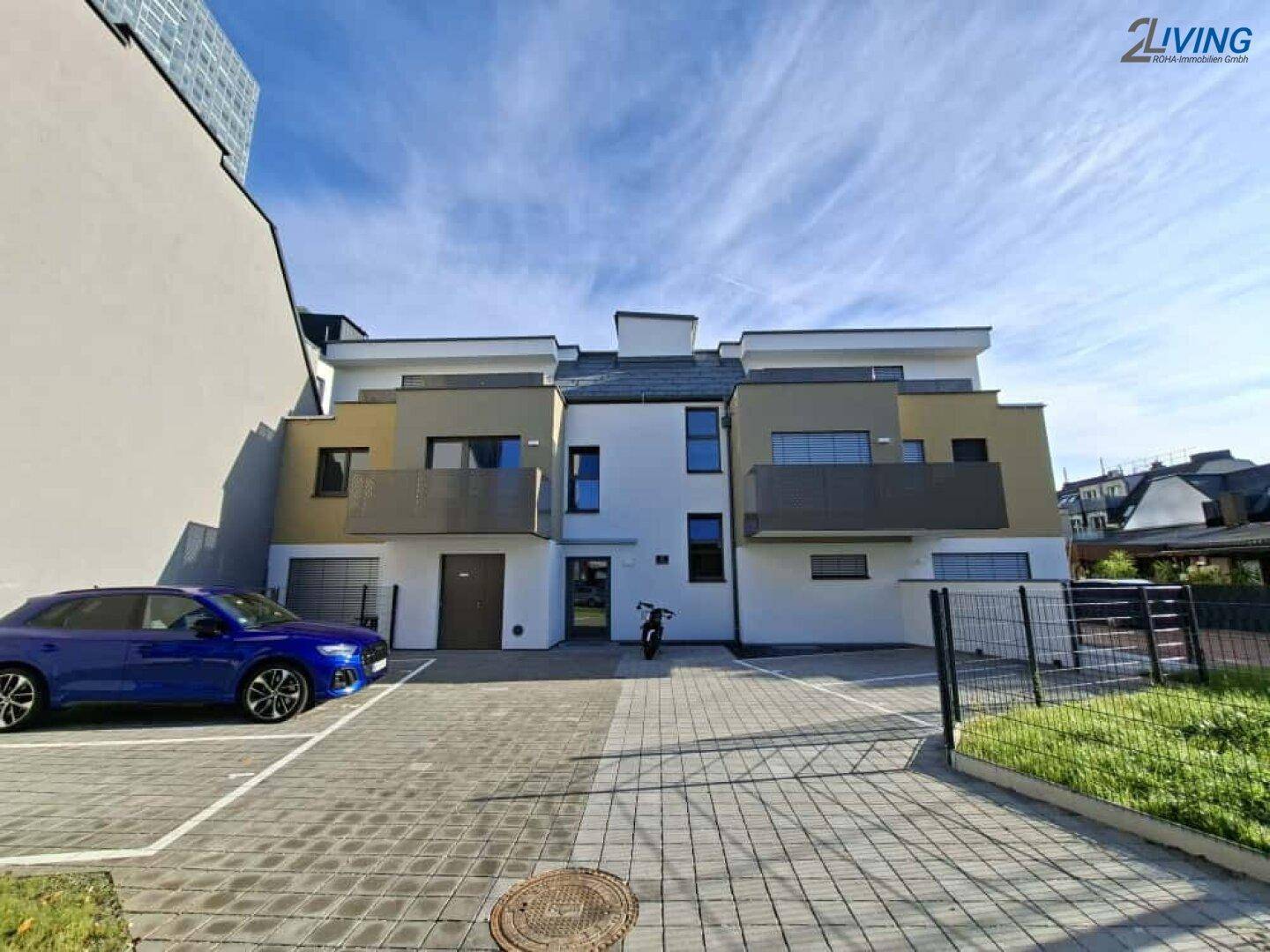 Moderne Wohnanlage mit mehreren Einheiten, Parkplätzen und zeitgenössischer Architektur.