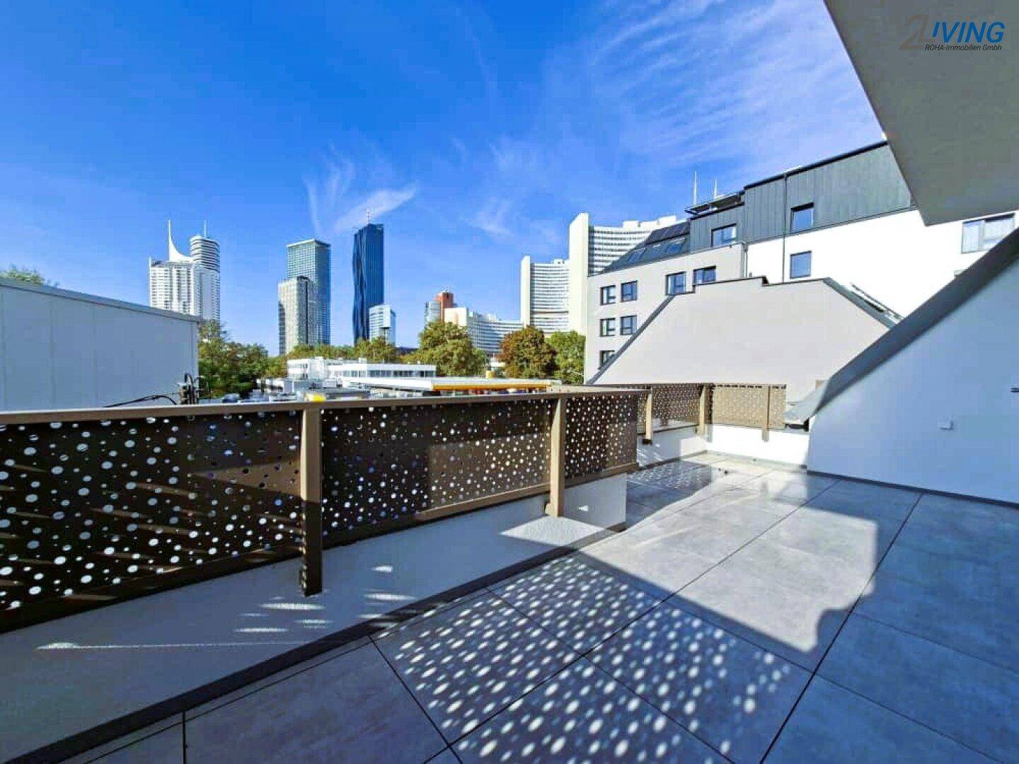 Weitläufige Dachterrasse mit moderner Brüstung und Panoramablick auf die Stadt.