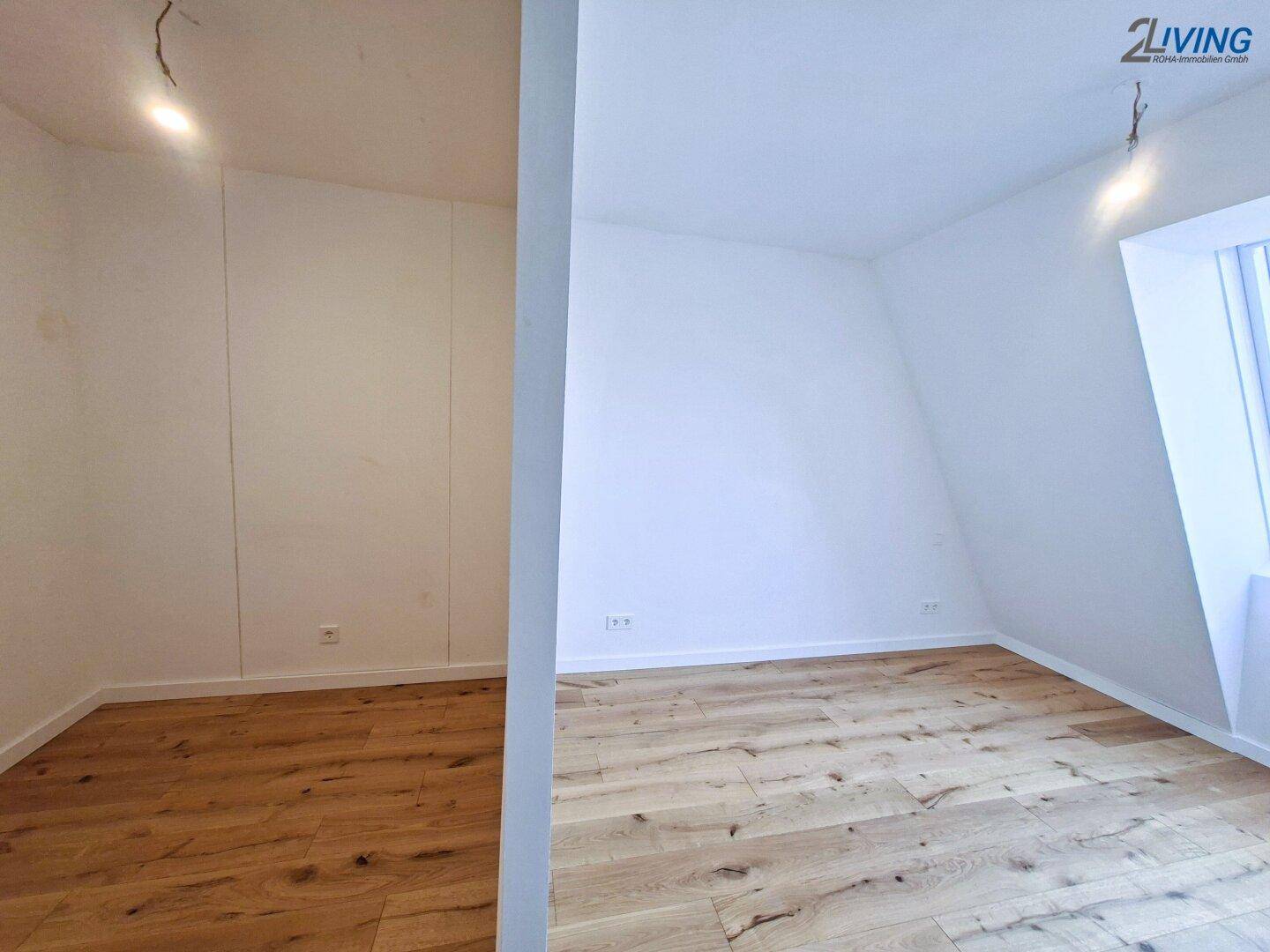 Helles Zimmer mit Holzboden und Dachschräge, ausgestattet mit einem Dachfenster für viel Tageslicht.