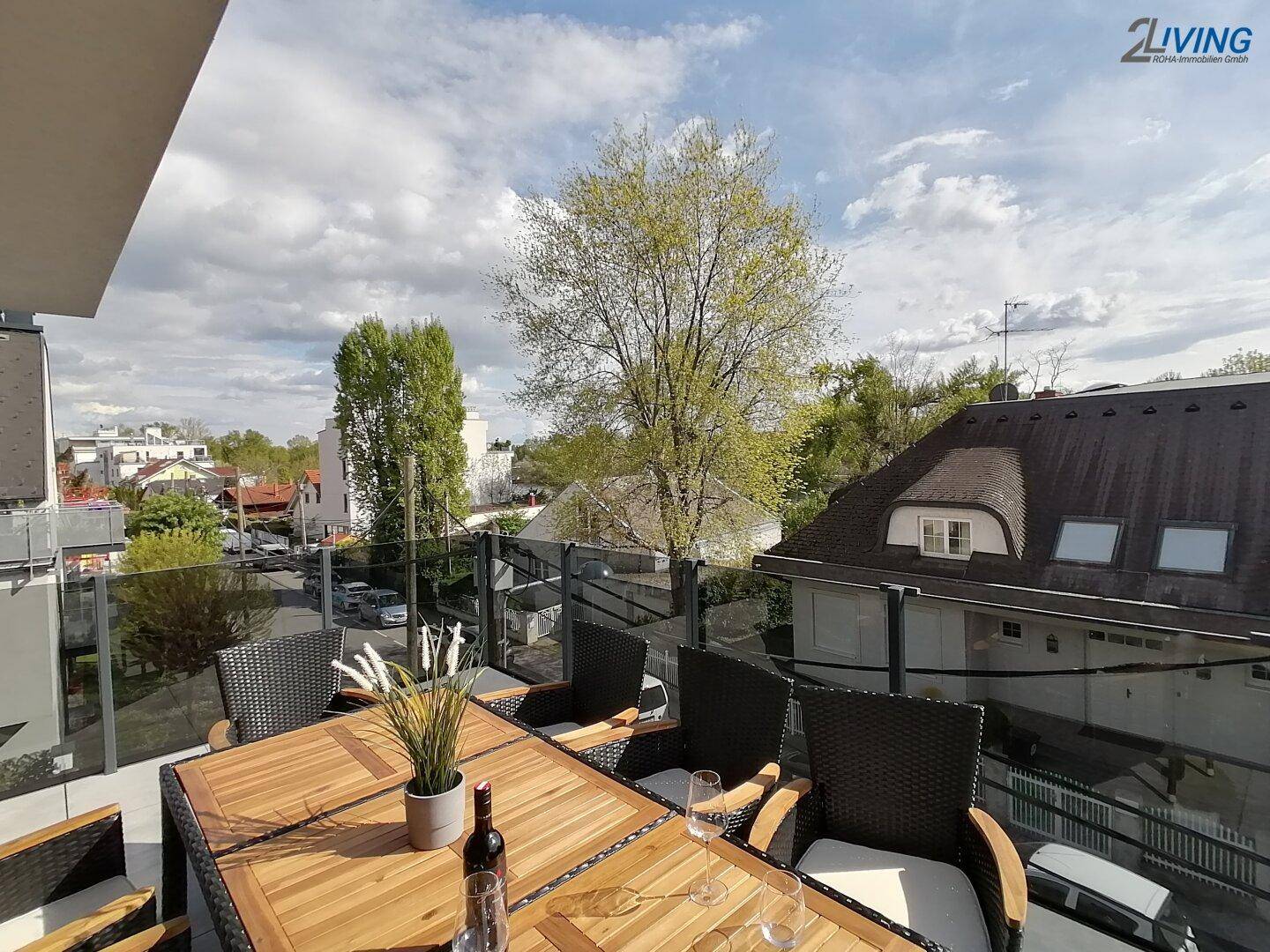 Geräumige Terrasse mit Holztisch und Stühlen, ideal für Mahlzeiten im Freien.