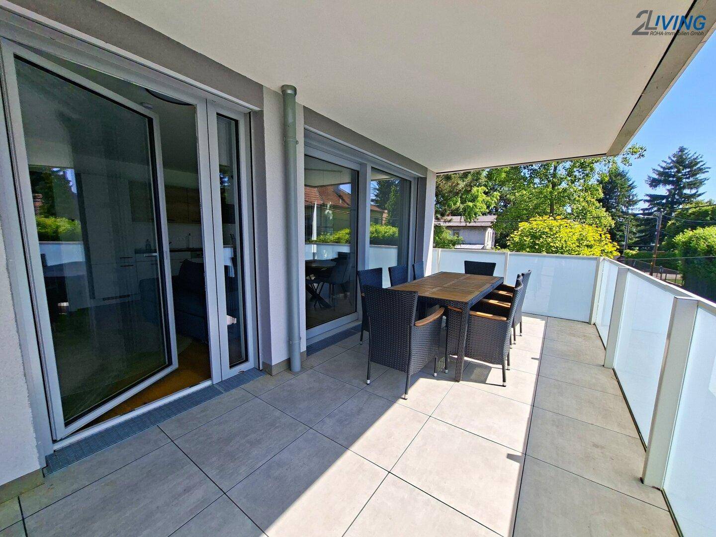 Geräumiger Balkon mit Fliesenboden und Outdoor-Sitzbereich, ideal zum Entspannen im Freien.
