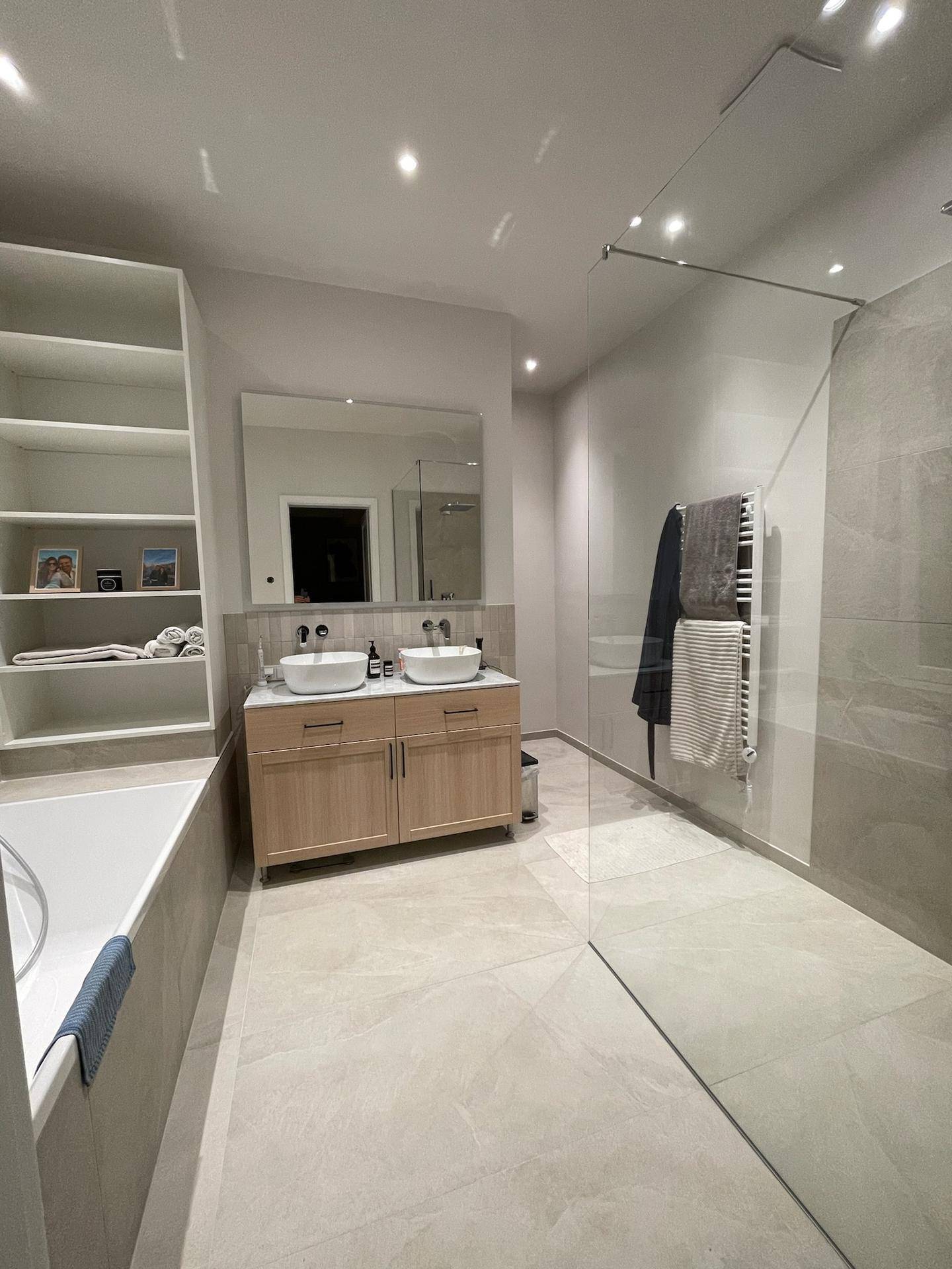 Modernes Badezimmer mit Doppelwaschbecken, Badewanne und großer begehbarer Dusche.