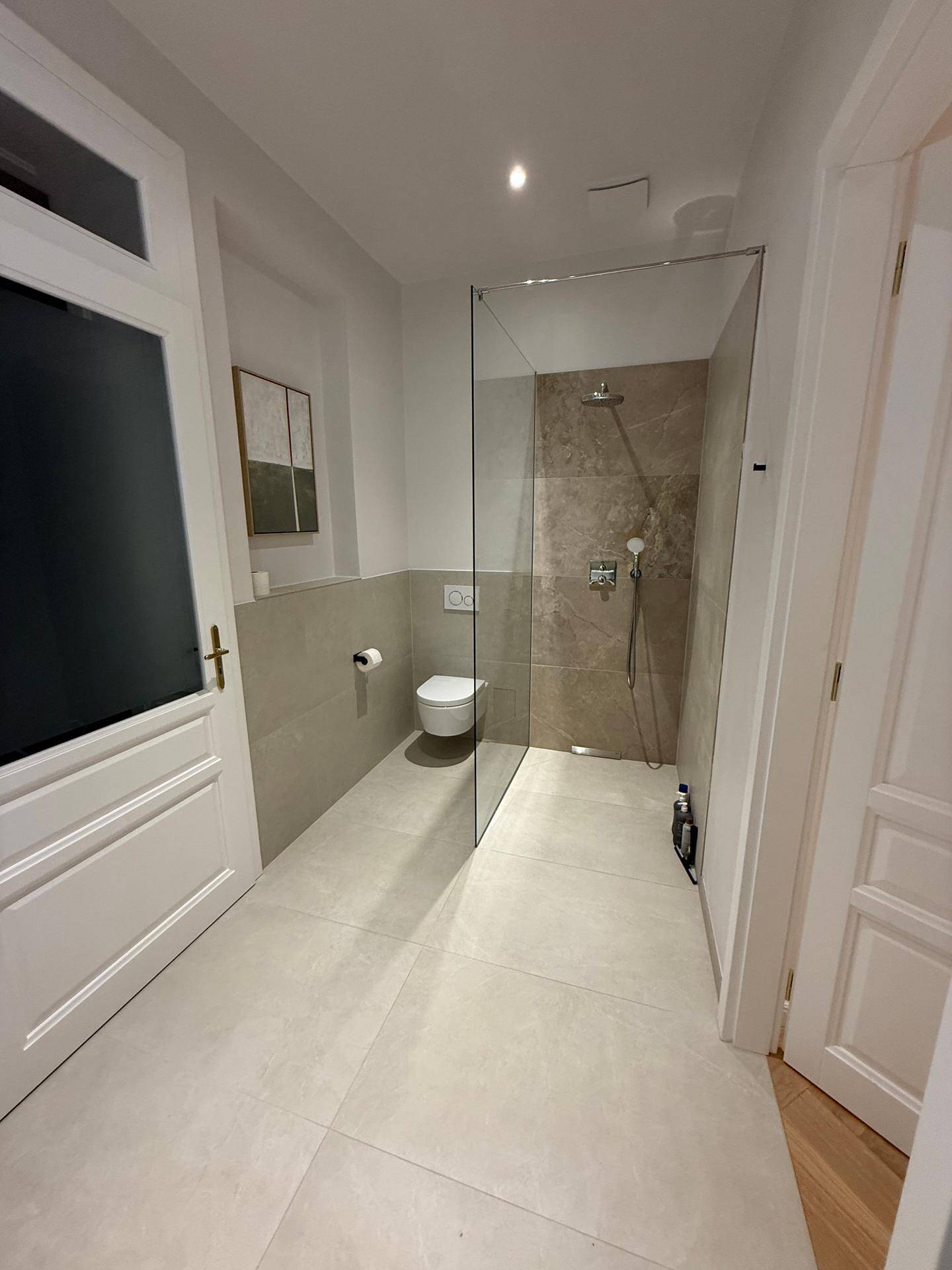 Modernes Gäste-WC mit wandhängender Toilette und begehbarer Dusche.