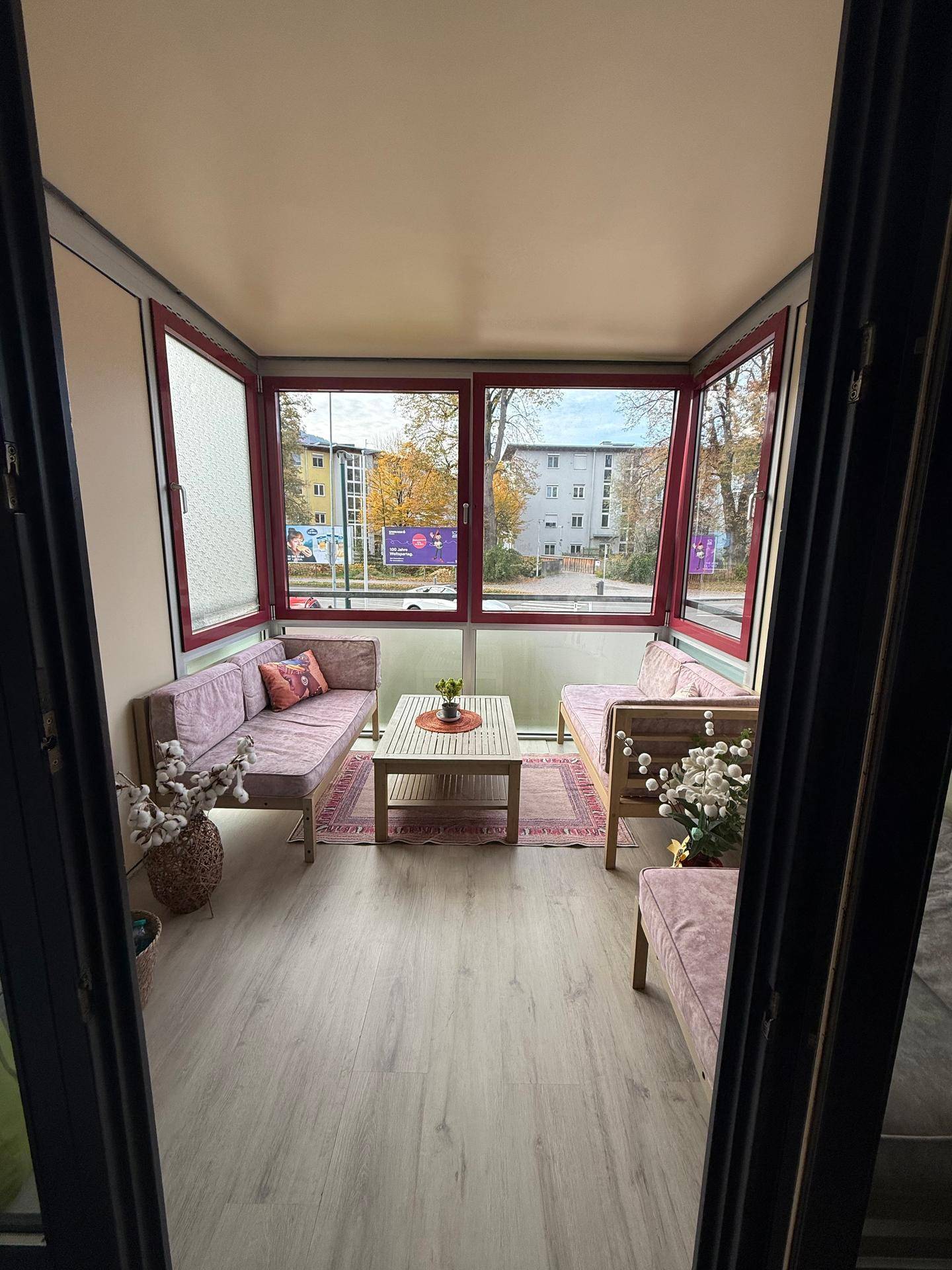 Verglaste Loggia mit Sitzgelegenheiten und Blick auf die Umgebung.